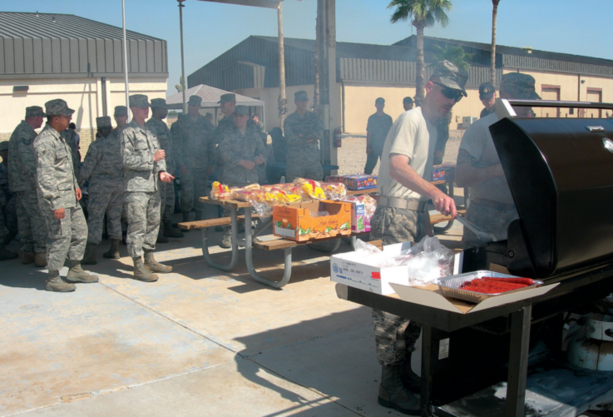 Master Sgt. John Wiggins, 607th Air Control Squadron resource advisor, cook burgers and hot dogs for members during a welcoming party for Col. Scott Fisher, 552nd Air Control Group commander. The 607th is a tenat unit at Luke Air Force Base and belong to the 552nd ACG, Tinker Air Force Base, Oklah. (U.S. Air Force photo/ Senior Airman Tong Duong.)
