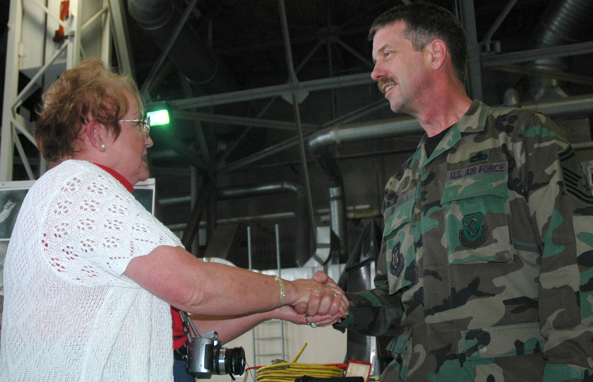 Joan Sell, Air Force Association Rocky Mountain Region president and a civic leader from Colorado Springs, Colo., presents Senior Master Sgt. James Nichols a wing commander coin for excellence Oct. 30 at McChord Air Force Base, Wash. A group of 25 civic leaders were sponsored by the 302nd Airlift Wing during a community relations tour to the Northwest base where they learned more about the Air Force Reserve mission. The 302nd AW is based out of Peterson AFB, Colo. (U.S. Air Force photo/Senior Airman Stephen Collier)