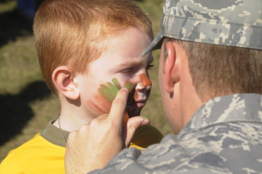 Cameron Reblin, 5, has his face painted with camo paint. U. S. Air Force photo by Sue Sapp
