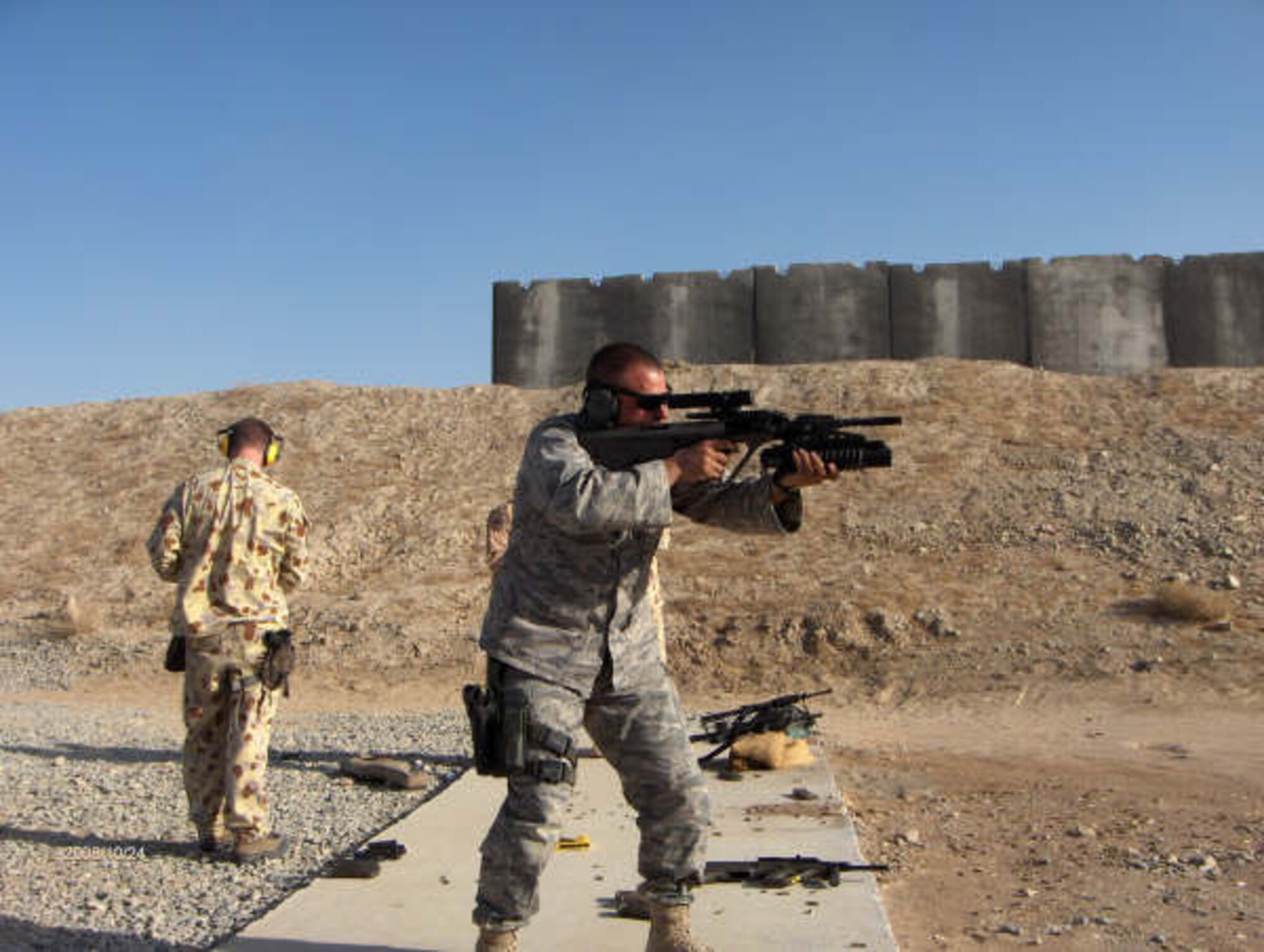 Major Robert Baird, 507th Security Forces Squadron commander is shown practicing at a weapons range while deployed at Afghanistan.  Above he is firing an Australian  Steyr AUG automatic rifle.  Regarding the rifle Major Baird said, "There's no selector switch so you have to push the trigger to the rear a bit more to go to auto... so follow through can be a problem."   The major also pointed out the Australian uniforms saying, "The “101 Dalmatians” uniform worn by the soldier in the background is the official Aussie version of our ABUs/DCUs.   We playfully tease them about it all the time!" Baird said.