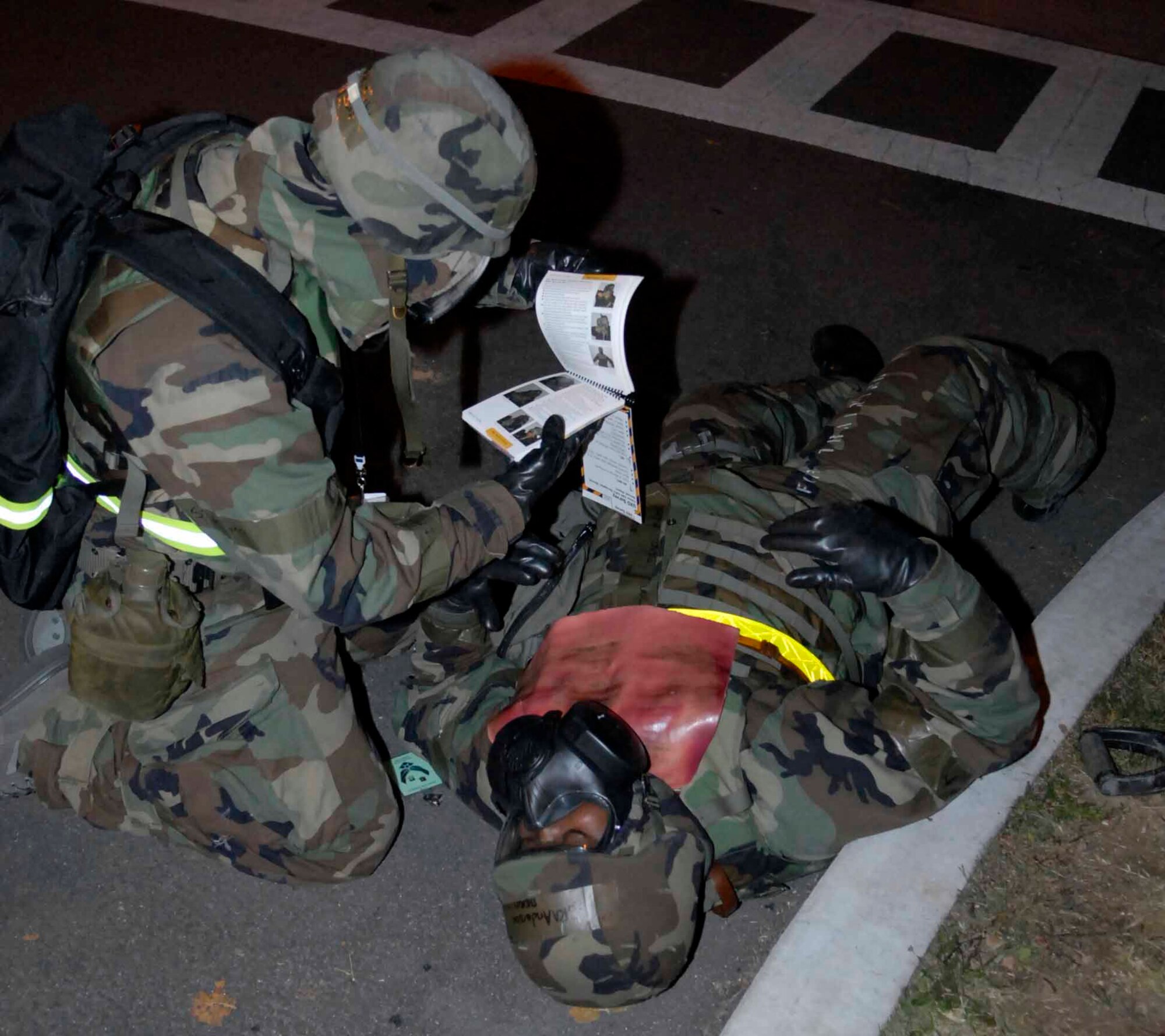 OSAN AIR BASE, Republic of Korea -- A member of a post attack reconnaissance team consults  his Airman’s Manual to find the correct self-aid buddy care  procedures to perform on a burn  “victim” following a simulated missile attack during exercise Beverly Bulldog 08-04 Nov. 6. The exercise tests Team Osan’s ability to transition from peacetime to wartime operations, execution of the mission in a war time environment, and response time to major accident and natural disasters. (U.S. Air Force photo/Staff Sgt. Scottie McCord)