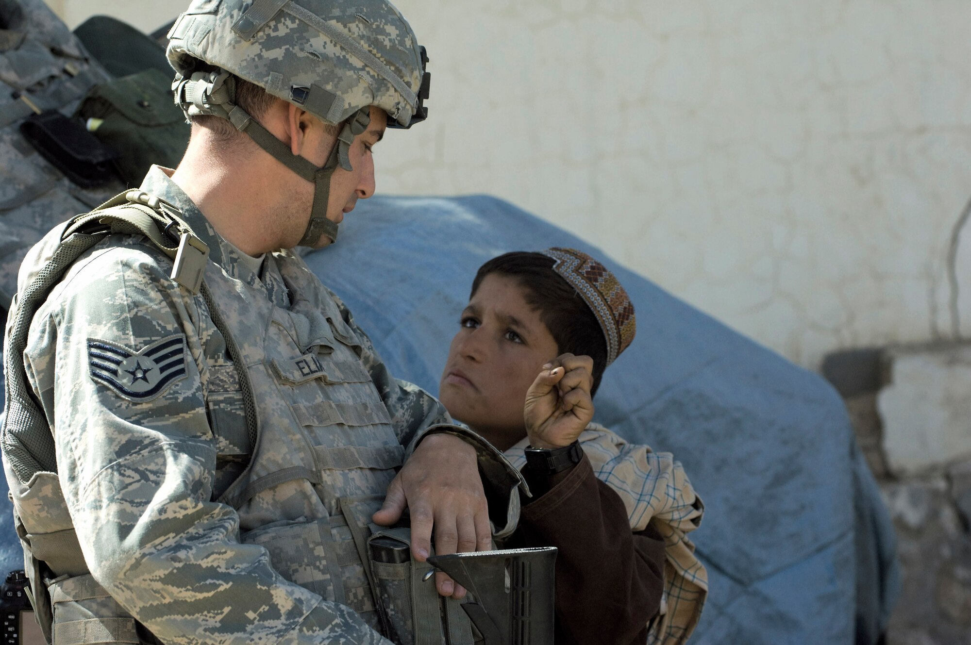 Staff Sgt. Don Elias talks with an Afghan boy while providing security at a veterinary outreach held by the Zabul Provincial Reconstruction Team Oct. 17 in Qalat, Afghanistan. The PRT provided free treatment to the nomadic Kuchi tribe's livestock. Sergeant Elias is deployed to the PRT as the force protection NCO in charge from Wright-Patterson Air Force Base, Ohio. He is a native of Buffalo, N.Y. (U.S. Air Force photo/Master Sgt. Keith Brown) 
