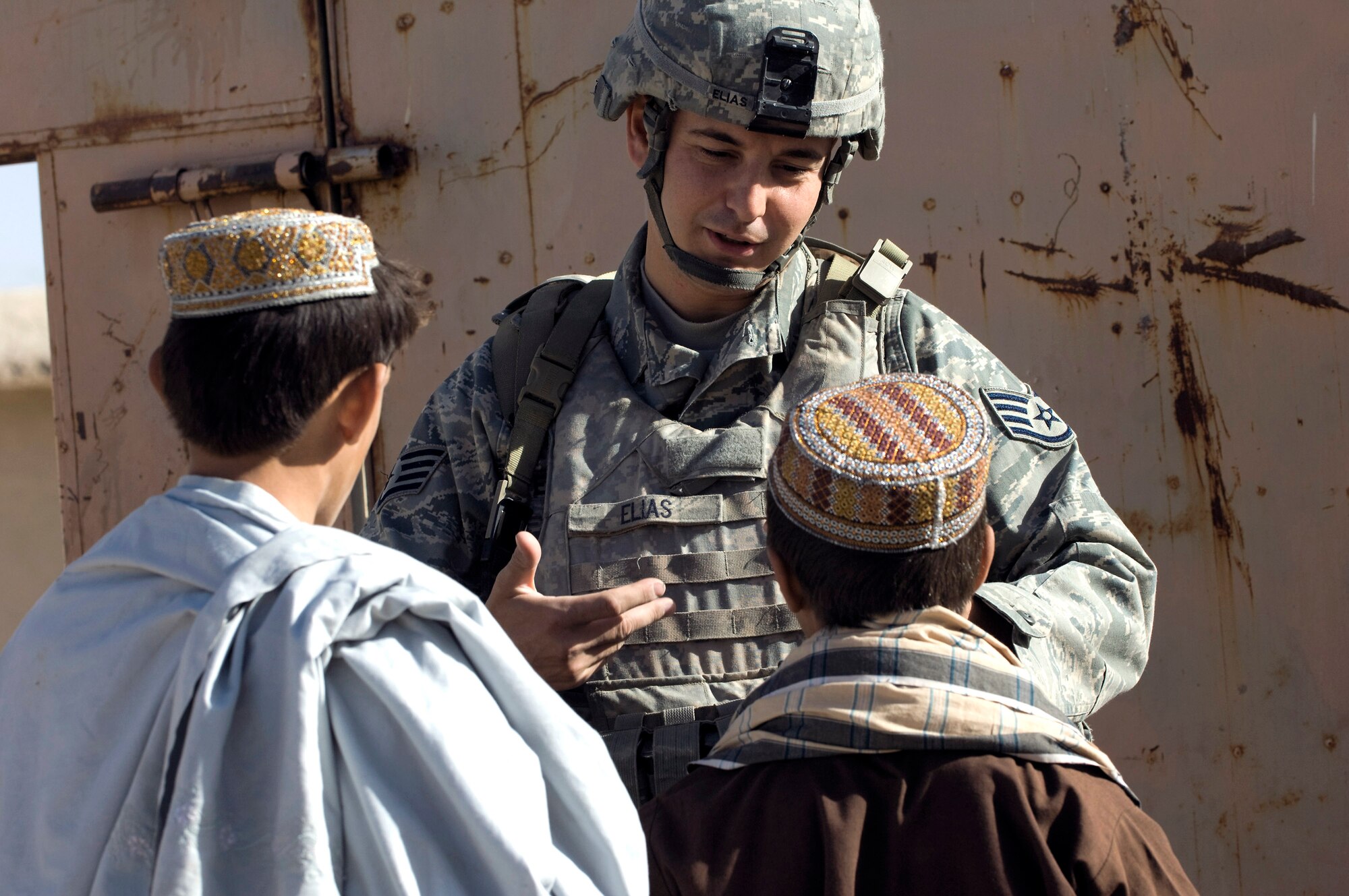 Staff Sgt. Don Elias talks with two Afghan boys while providing security during a veterinary outreach held by the Zabul Provincial Reconstruction Team Oct. 17 in Qalat, Afghanistan. The team provided free treatment to the nomadic Kuchi tribe's livestock. Sergeant Elias is deployed to the PRT as the force protection NCO in charge from Wright-Patterson Air Force Base, Ohio. He is a native of Buffalo, N.Y. (U.S. Air Force photo/Master Sgt. Keith Brown) 
