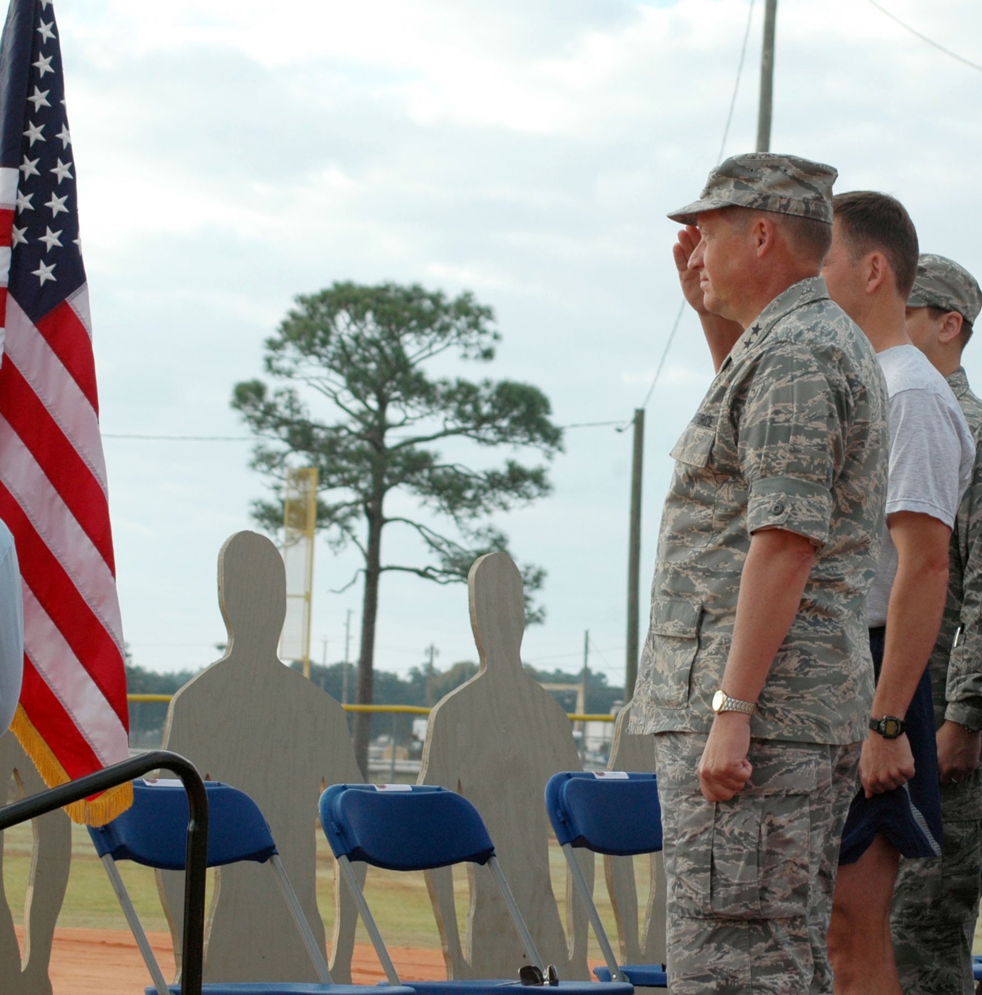 EGLIN AIR FORCE BASE, Fla. -- Maj. Gen. David Eidsaune, Air Armament Center Commander and Air Force Program Executive Officer for Weapons, and Col. Bruce McClintock, 96th Air Base Wing Commander, saluted the American Flag Nov. 6 as the Start Spangled Banner was played at the beginning of Wingman Day. In the background, there are cutouts of Airmen at attention symbolizing fallen Airmen and Airmen who are currently deployed in support of the Global War on Terror. (U.S. Air Force photo/Staff Sgt. Stacia Zachary)