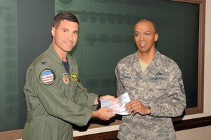 LANGLEY AIR FORCE BASE Va.--Col. Jeffrey Prichard, 1st Fighter Wing vice commander, presents Senior Master Sgt. Leslie Gould, 735th Supply Chain Management Group first sergeant and president of Langley First Sergeants Association, with a check worth more than $12,800 in support of Operation Warm Heart here Nov.4. Operation Warm Heart is a Langley First Sergeants Association community outreach program designed to support Airmen during the holiday season. (U.S. Air Force photo/Airman 1st Class Jonathan Koob)
