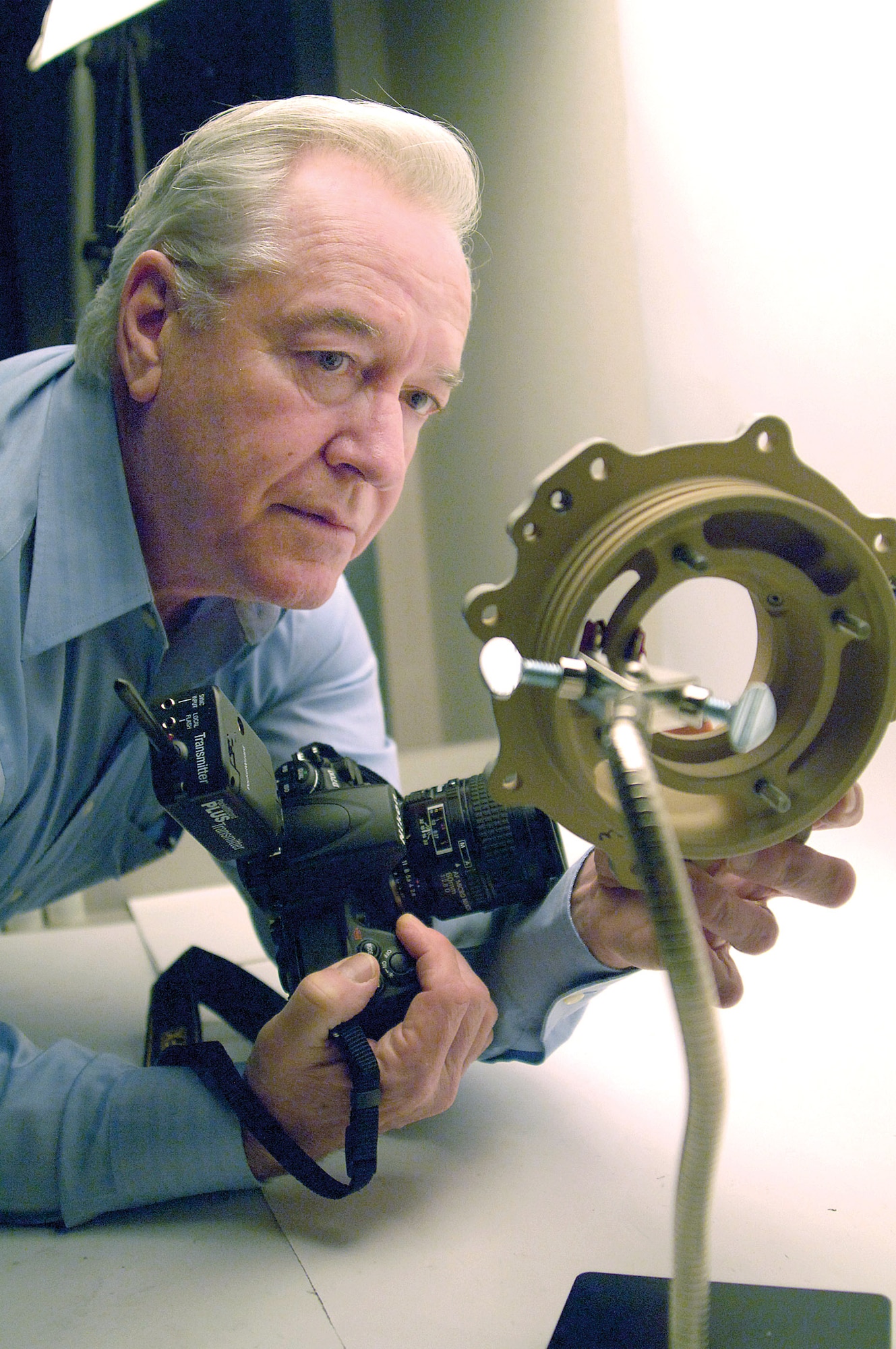Larry Smith prepares a part before photographing it in the Metallurgical Sciences Laboratory in Bldg. 3001.  The photographer helps Tinker engineers by documenting specifics of new or failed components. During the Vietnam War, Mr. Smith was a private first class with the 2nd Battalion, 9th Marine Regiment, earning two Purple Heart medals.  (Air Force photo/Margo Wright)