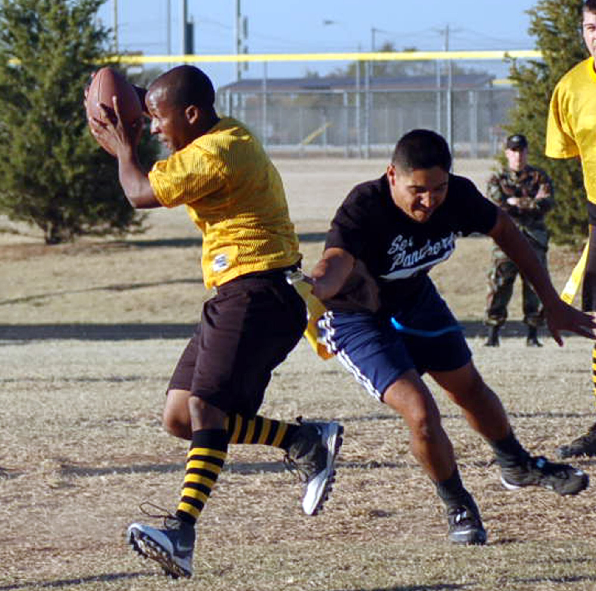 Jacob Moreno, 327th Aircraft Sustainment Wing defensive end, right, grabs the flag of 34th Combat Communications Squadron quarterback Michael Elliott during the second quarter of an Oct. 30 game at the Tinker Sports Complex. The 327th ASW won 14-0.