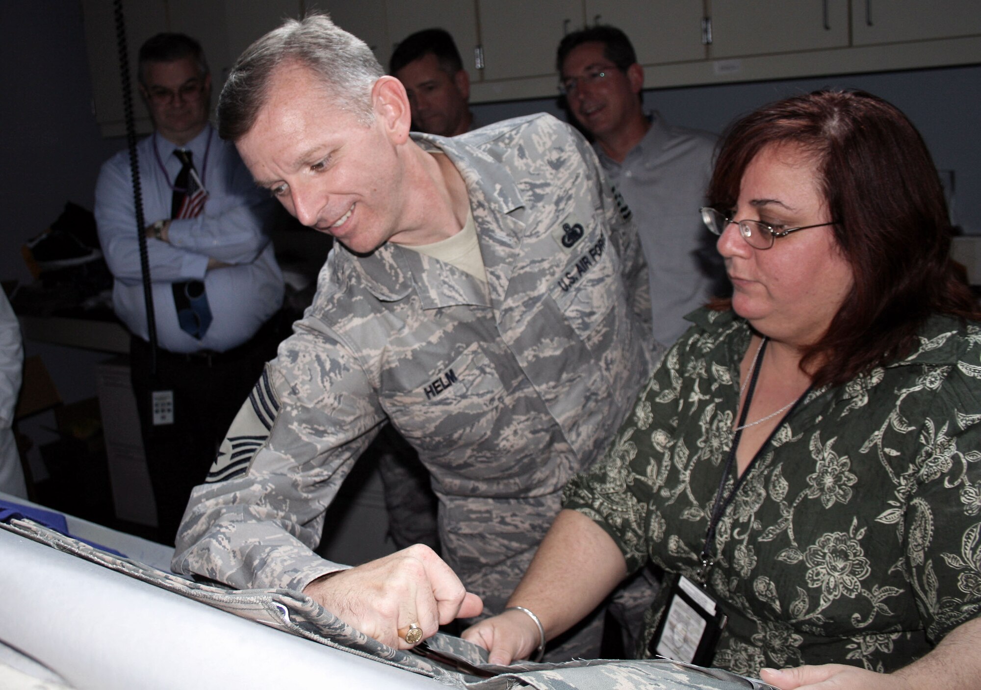 Chief Master Sgt. Jeffry Helm compares his Airman Battle Uniform to a sample provided by Jamie Hieber, color scientist, during his visit to Defense Supply Center Philadelphia, Oct. 23. AAFES, DSCP and the Air Force officials are working together to fix the range of the color deviation of the ABU. Chief Helm is the Army and Air Force Exchange Service enlisted advisor to the commanding general. (U.S. Air Force photo) 
