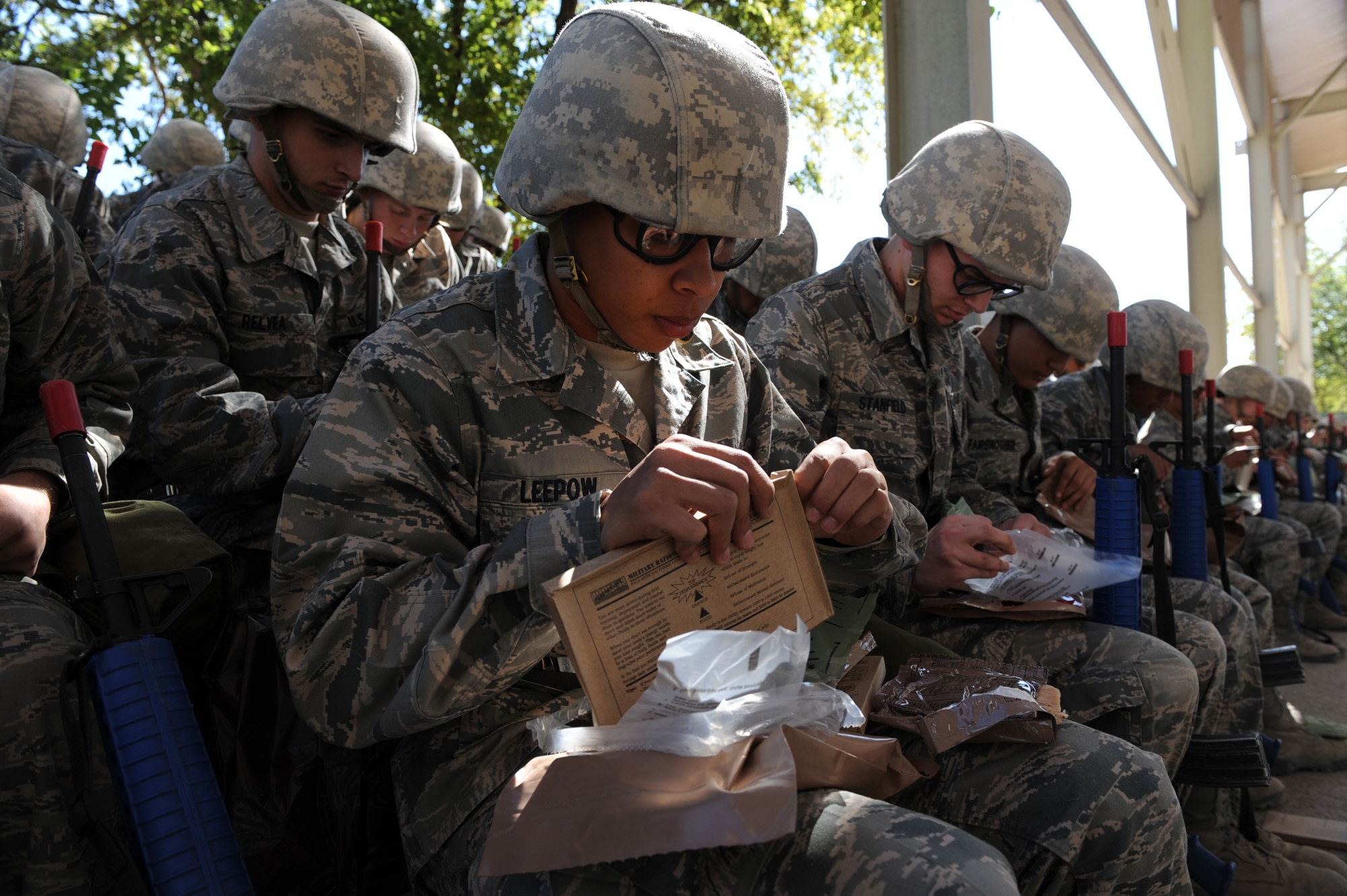Basic trainees take a break during briefings to eat Meals, Ready to Eat during a field training exercise Oct. 28 at Lackland Air Force Base, Texas. (U.S. Air Force photo/Staff Sgt. Desiree N. Palacios)