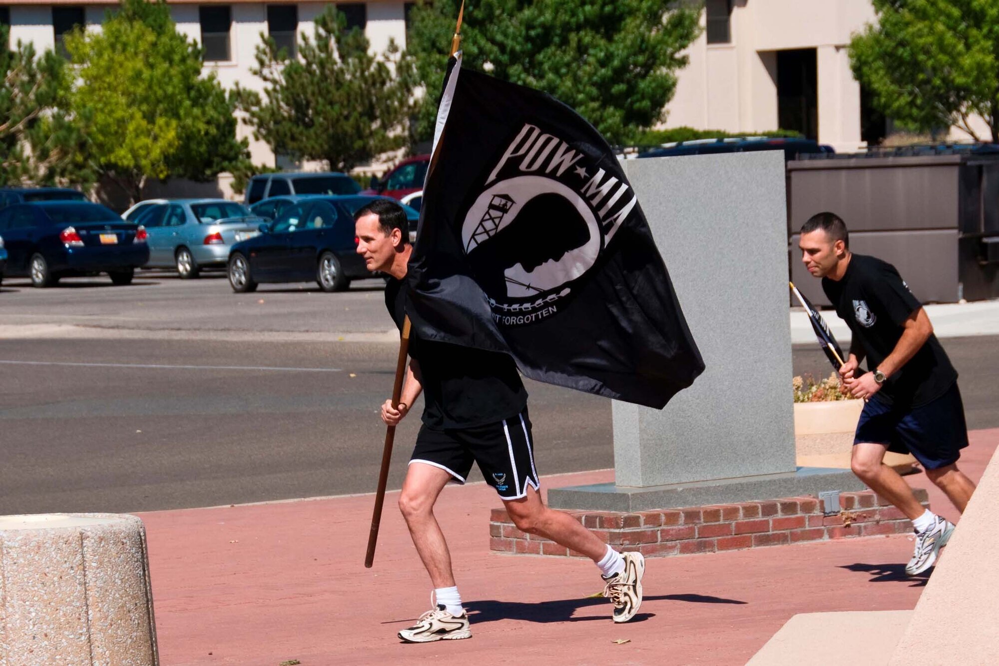 Col. Robert Campbell, Jr., Air Force Operational Test and Evaluation Center Detachment 3 Commander, carries the POW/MIA flag on the inaugural lap of the annual POW/MIA 24-hour run held each September at Kirtland AFB, N.M.