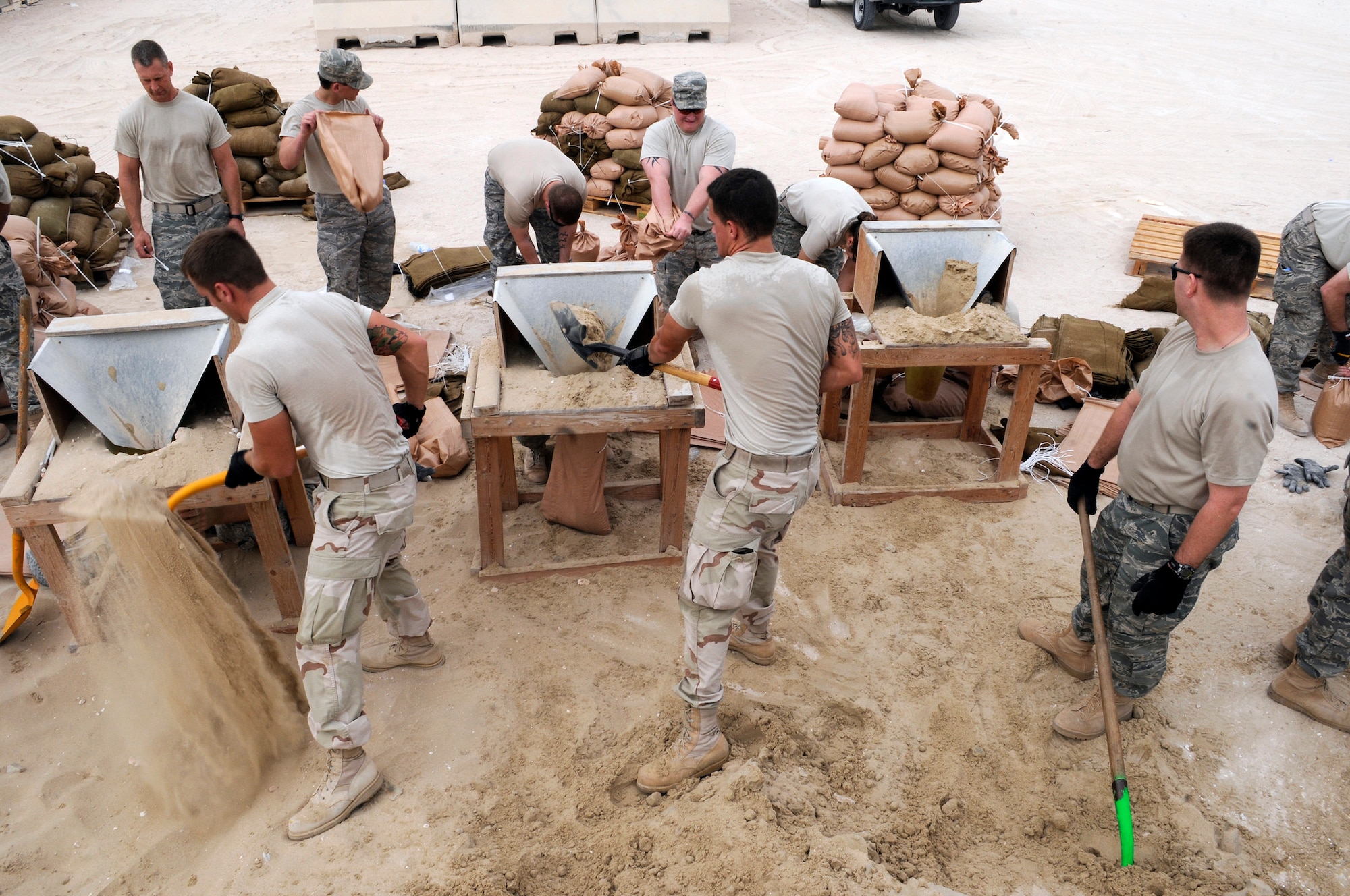 Airmen from the 379th Expeditionary Communications Squadron fill sandbags Nov. 4 at an air base in Southwest Asia. The sandbags will be used to fortify emergency bunkers.  The Airmen are deployed here in support of operations Iraqi Freedom and Enduring Freedom and Joint Task Force-Horn of Africa.  (U.S. Air Force photo/Tech. Sgt. Michael Boquette)