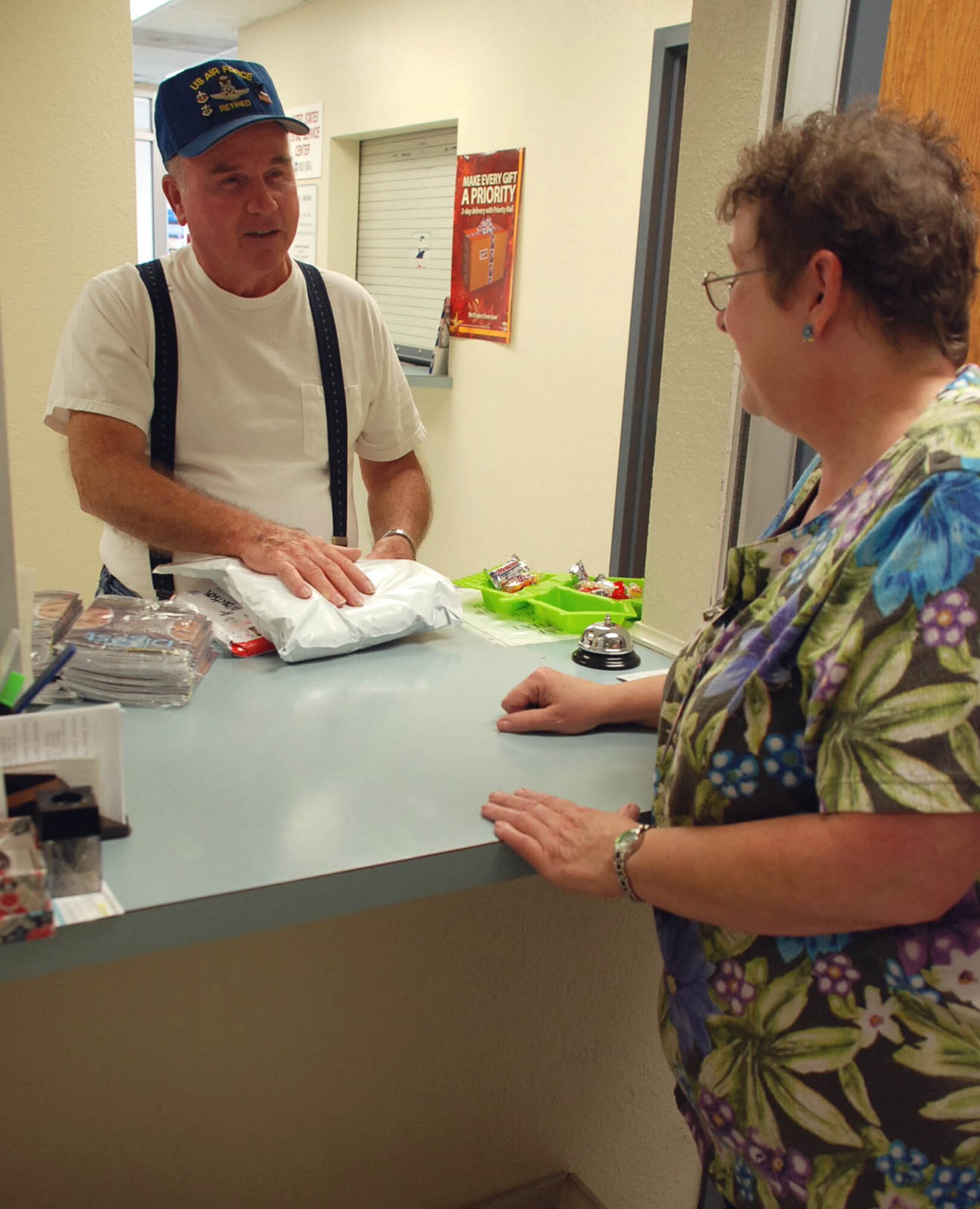 LAUGHLIN AIR FORCE BASE, Texas – Lois Hurley, mail room supervisor with the 47th Installation Support Squadron, hands John Albertson, retired veteran, a package at the official mail center here November 3. The mail room provides postal service for all enlisted Airmen living in the dorms and all official mail for agencies throughout the base. “I get to give Airmen packages they have been waiting on for so long,” said Hurley, who has been working in the mail room for more than nine years. “I love being one of the best parts of their days.” (U.S. Air Force photo by Airman 1st Class Sara Csurilla)
