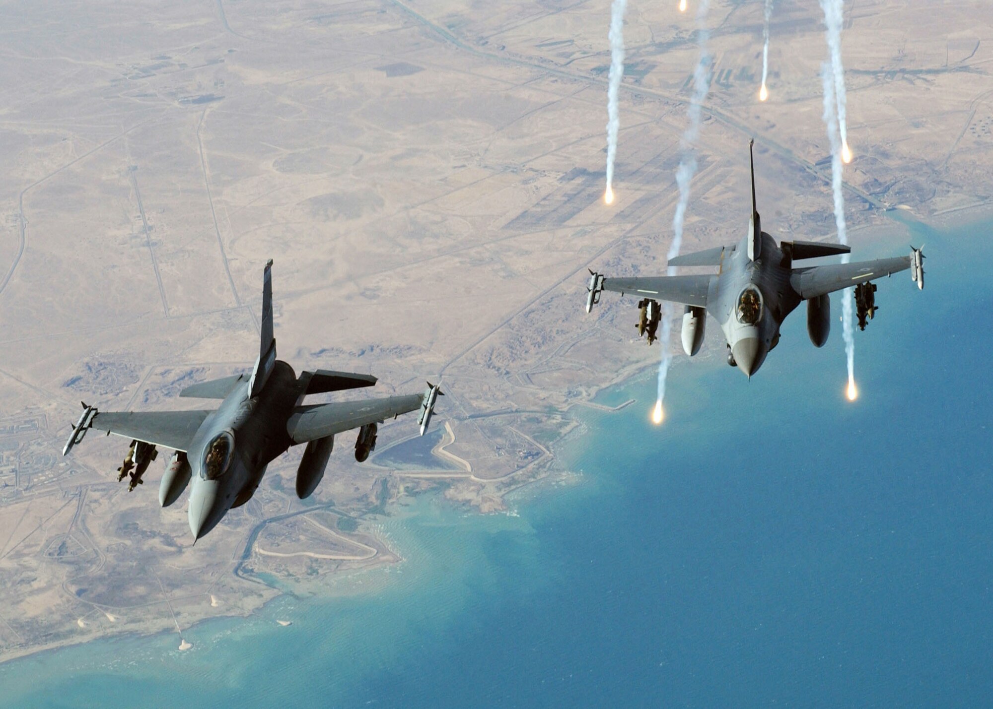 An F-16 Fighting Falcon launches electronic countermeasure flares following an aerial refueling mission over Iraq. F-16s provide armed aerial overwatch and is a compact, multirole fighter aircraft with high maneuverability. (Defense Department photo)  