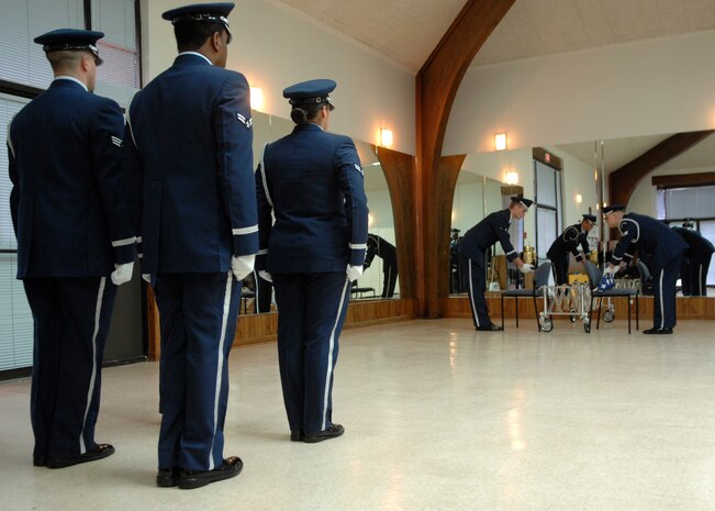 Members of the honor guard team perform a mock cremation ceremony after the ribbon cutting ceremony for their new training facility in Hunley Park Nov. 5. The honor guard relocated to a renovated building in Hunley Park to provide a better training environment. (U.S. Air Force photo/Airman 1st Class Katie Gieratz)