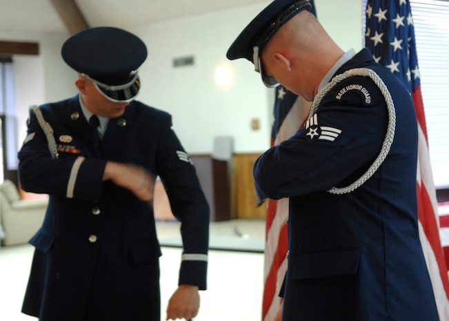 Senior Airman Brandon Harris checks himself in the mirror for lint on his uniform in preparation for the ribbon cutting ceremony of the new honor guard training facility in Hunley Park Nov. 5. The honor guard relocated to a renovated building in Hunley Park to provide a better training environment. Airman Harris is with the 437th Logistics Readiness Squadron. (U.S. Air Force photo/Airman 1st Class Katie Gieratz)