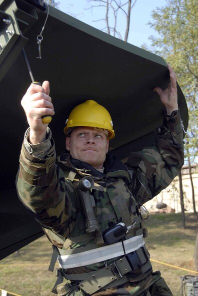 OSAN AIR BASE, Republic of Korea -- Tech. Sgt. Richard Davis, 607th Support Group satellite wide band and telemetry systems technician, practices a unique capability that allows Osan computers and telephone traffic to be routed up to a satellite and then on to its destination, instead of "flowing" through cables in the ground. Establishing back-up systems to link normal communications networks is critical should normal communications systems fail during a contingency. (U.S. Air Force photo/Staff Sgt. Lakisha Croley)