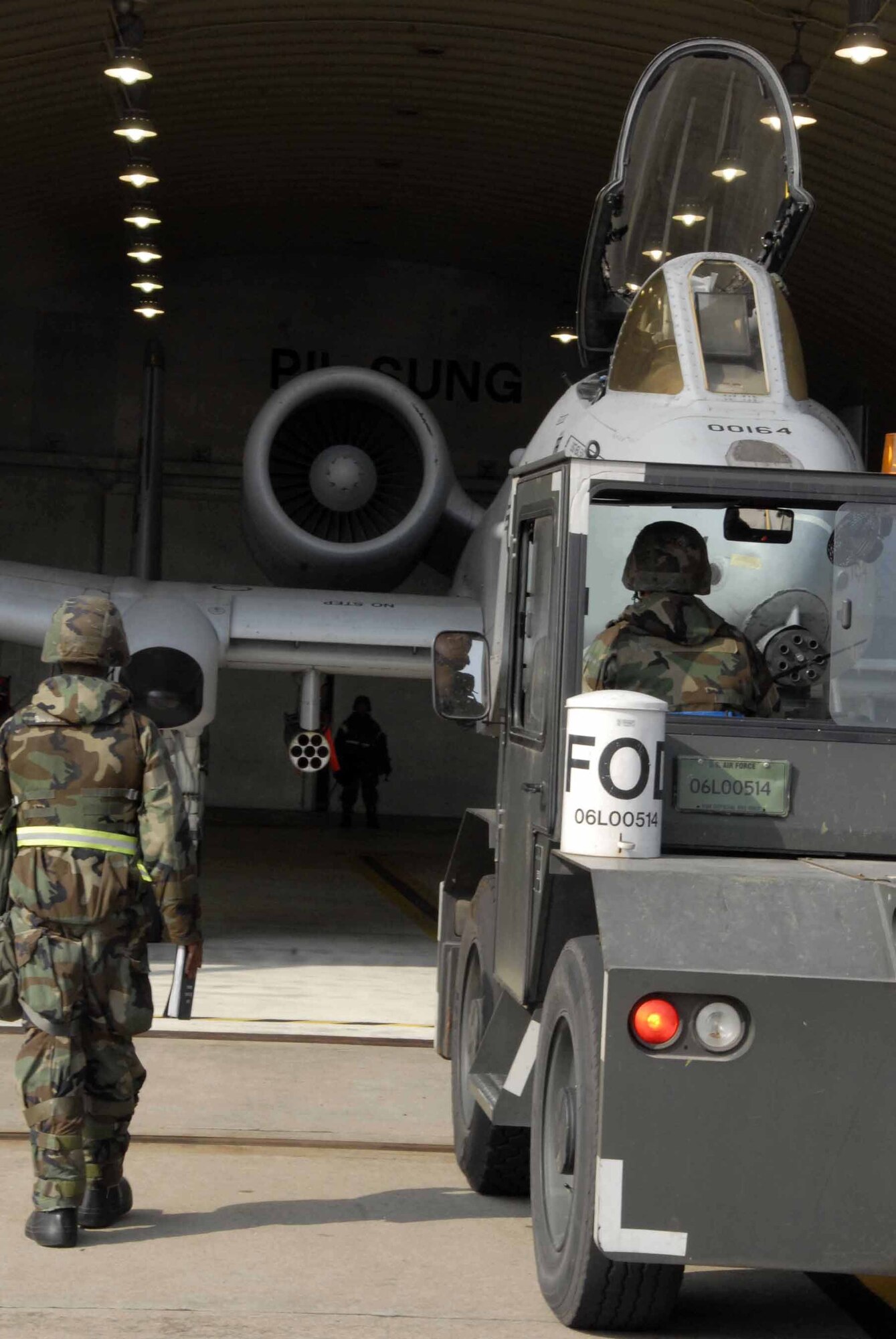 OSAN AIR BASE, Republic of Korea -- Staff Sgt. James Sturgis, (left), and Airman First Class Manuel Quiroz assist in the recovery of an A-10 Thunderbolt during a base wide exercise 5, November 2008, Osan Air Base. The exercise occurs quarterly and is used to test personnel's ability to transition from peacetime to wartime operations, execution of the mission in a war time environment, and response time to major accident and natural disasters. Both Airmen are crew chiefs assigned to the 51st Aircraft Maintenance Squadron (U.S. Air Force/Staff Sgt. Lakisha Croley)