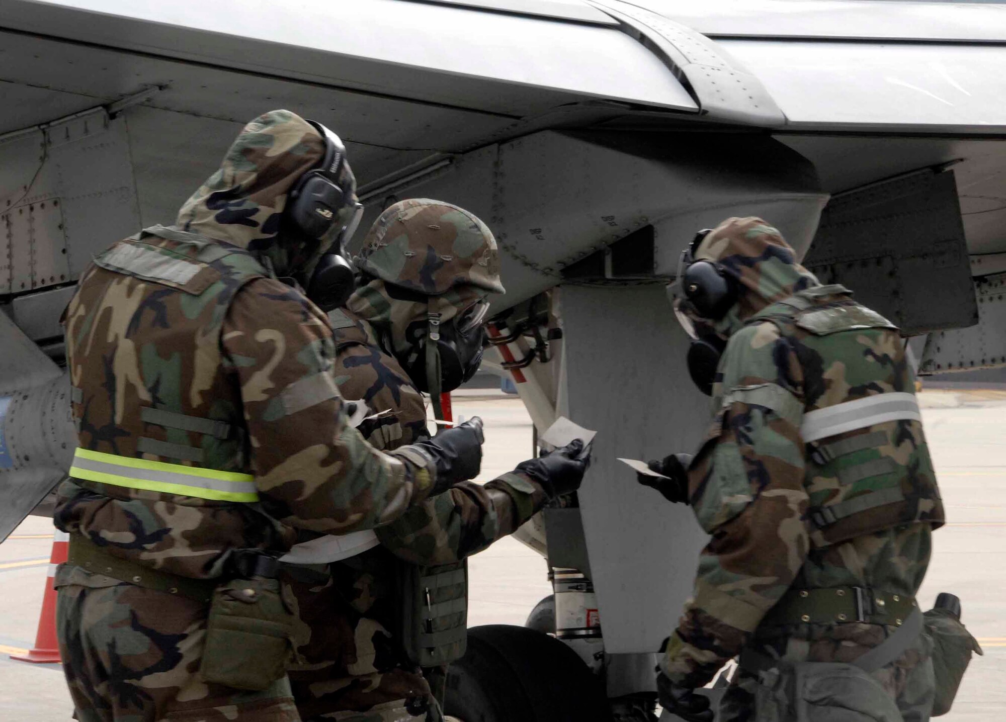 OSAN AIR BASE, Republic of Korea -- Members of the 25th Aircraft Maintenance Unit check M-8 paper (simulated) as they decontaminate an A-10 Thunderbolt during Exercise Beverly Bulldog 08-04 Nov. 6. The exercise tests Team Osan’s ability to transition from peacetime to wartime operations, execution of the mission in a war time environment, and response time to major accident and natural disasters. (U.S. Air Force/Staff Sgt. Lakisha Croley)