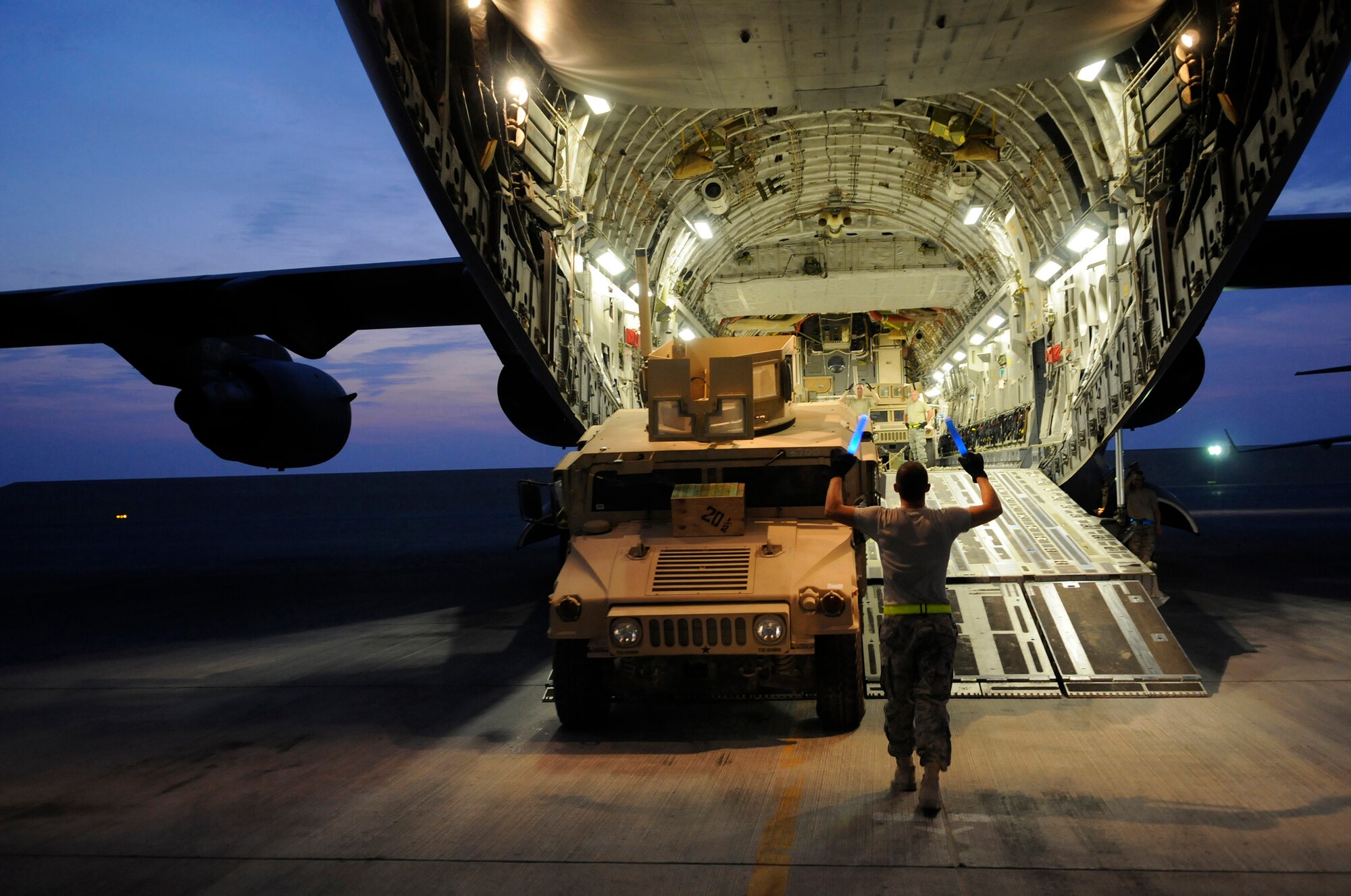 Airman 1st Class Richard True, aerial transportation apprentice assigned to the 8th Expeditionary Air Mobility Squadron, helps back a fully armored High Mobility Multipurpose Wheeled Vehicle into a C-17 Globemaster III, Nov. 5, at an undisclosed air base in Southwest Asia.  Airman Andrew Rose, aerial transportation apprentice assigned to the 8th EAMS drives the Humvee while Staff Sgt Daniel Carter, aerial port expediter assigned to the 8th EAMS, signals directions for placing eight Humvees inside the C-17.  Sergeant Carter, a native of Elgin Ill., is deployed from Charleston Air Force Base, S.C.  Airman True hails from Lykens, Pa., and is deployed from Dover Air Force Base, Del.  Airman Rose, from Cedar Falls, Iowa, is deployed from Travis Air Force Base, Calif.  All three are deployed in support of Operations Iraqi and Enduring Freedom and Joint Task Force-Horn of Africa. (U.S. Air Force photo by Tech. Sgt. Michael Boquette/Released)