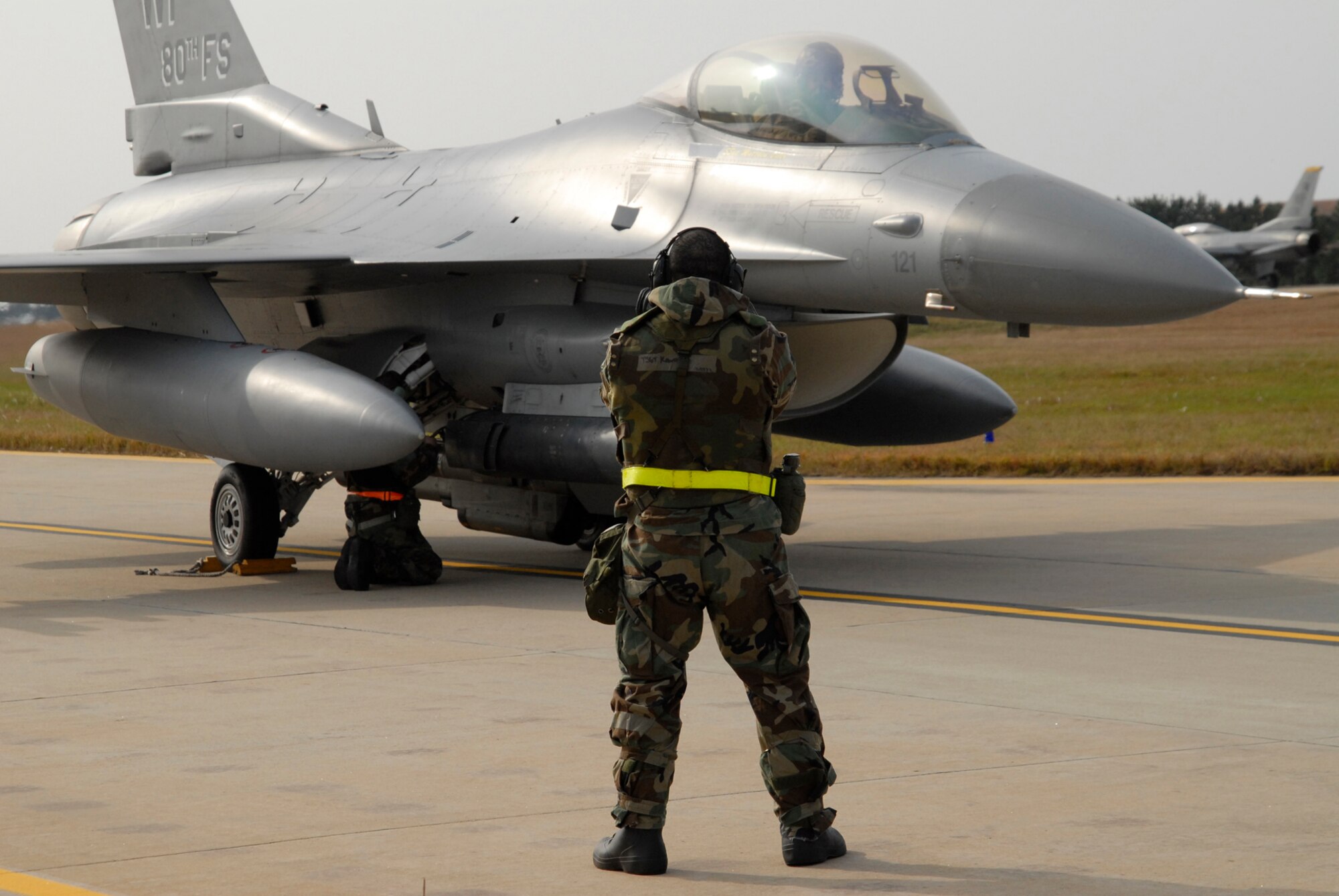Lt. Col.Kevin Sutton, 80th Fighter Squadron director of operations, sits on the taxiway at Kunsan Air Base, Republic of Korea while Senior Airman Chad Wooldridge, Avionics Specialist with the 80th Aircraft Maintenance Unit, and Tech. Sgt. Amer Kawasmi, 80th AMU Specialist Expeditor, perform an end of runway inspection during the Peninsula-Wide Operational Readiness Exercise, Nov. 5, 2008. Kunsan is participating in the PENORE as a test of its wartime capabilities and response actions (U.S. Air Force Photo by SSgt Jason Colbert)