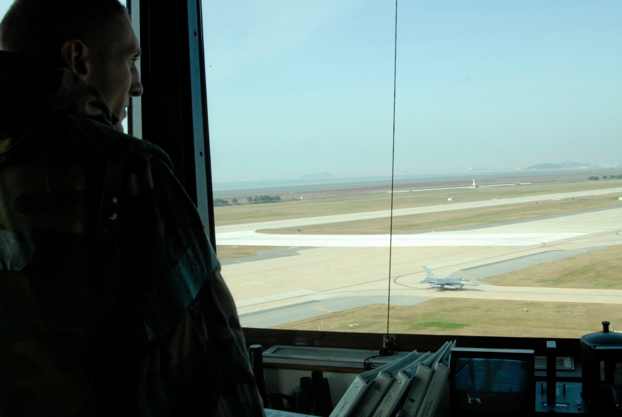Master Sgt. Travis Utz, watch supervisor, watches jets taxi from the air traffic control tower at Kunsan Air Base, Republic of Korea after directing them in during the Peninsula-Wide Operational Readiness Exercise, Nov. 5, 2008. Kunsan is participating in the PENORE as a test of its wartime capabilities and response actions (U.S. Air Force Photo by SSgt Jason Colbert)
