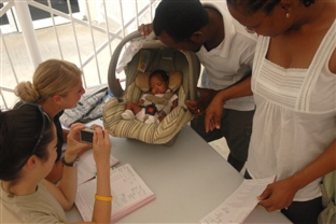 U.S. Air Force Staff Sgt. Danae Eskridge and Senior Airman Alexandra Olsen, embarked aboard USS Kearsarge, admire a newborn baby while checking in patients at the Couva District Health Facility during Continuing Promise 2008, Couva, Trinidad and Tobago, Nov. 3, 2008. The USS Kearsarge is the primary platform for the Caribbean phase of the humanitarian/civic assistance mission.