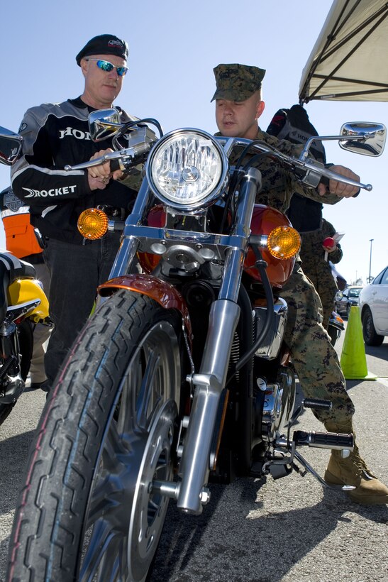 Staff Sgt. Brandon B. Baumgardener, Headquarters Support Battalion receives a lesson on motorcycle safety from David W. Lynch, a Lejeune Honda dealer and certified motorcycle safety officer at the Camp Lejeune exchange, Nov. 6.