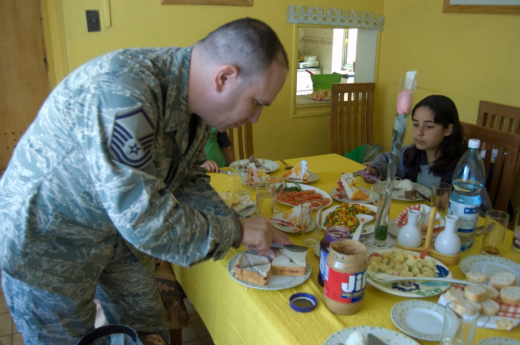 Master Sgt. Eric M. Grill, from the Defense Media Activity-San Antonio in Texas, cuts a peanut butter and jelly sandwich into quarters before serving it to Chilean children at the ALDEAS SOS orphanage in Santiago, Chile on Oct. 29. Sergeant Grill is in South America supporting Operation Southern Partner, a Twelfth Air Force (Air Forces Southern) led event aimed at providing intensive, periodic subject-matter exchanges in the U.S. Southern Command area of focus, started Oct. 26 and ends Nov. 7. (Air Force photo\Dana Willis)
