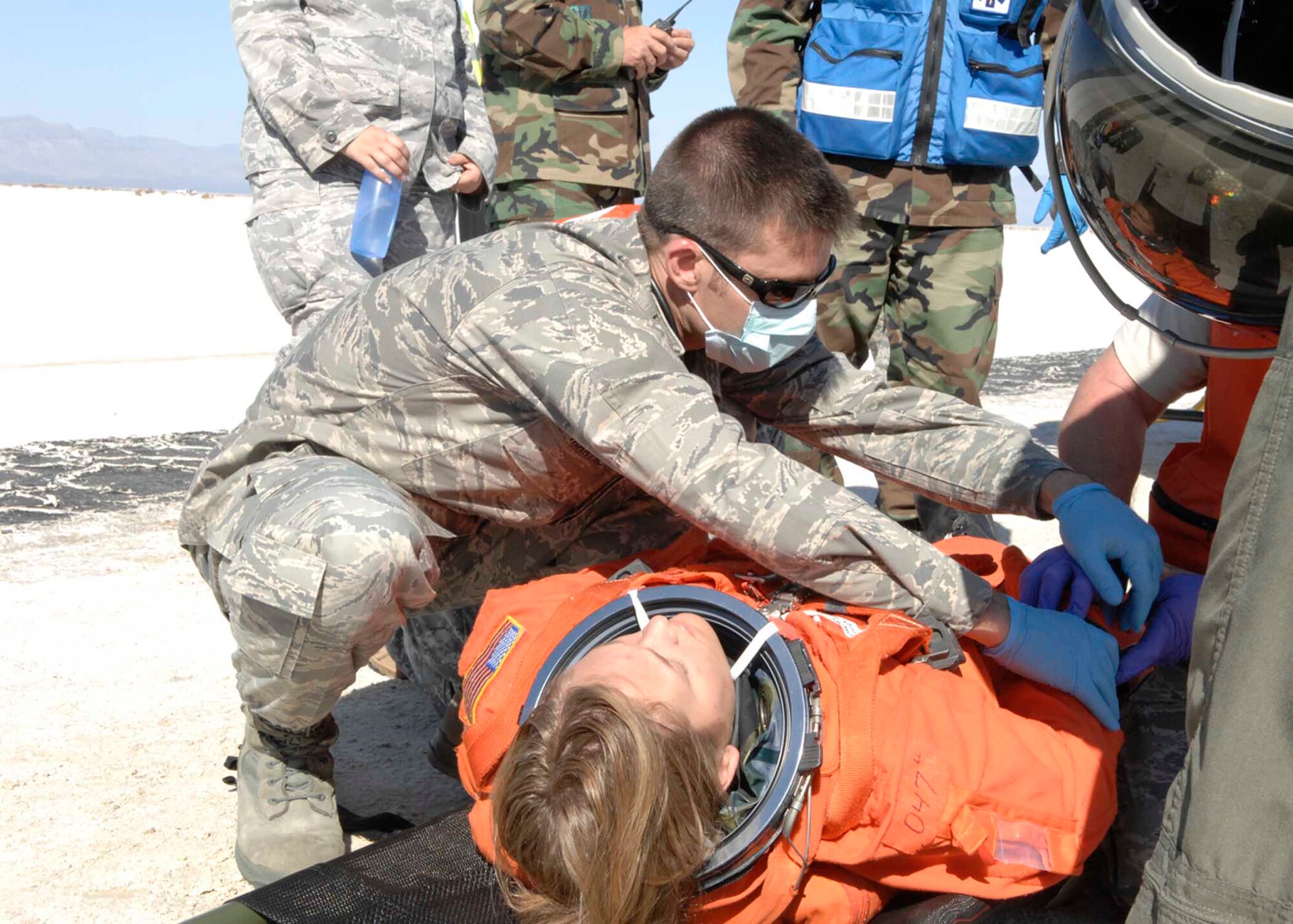 Holloman medical personnel care for a shuttle team member during a simulated shuttle landing exercise. Approximately 60 members from Holloman, White Sands Missile Range and the National Aeronautics and Space Administration (NASA) came together for a shuttle emergency landing exercise at the White Sands Space Harbor, Oct. 30. (U.S. Air Force photo/Airman 1st Class Rachel A. Kocin)
