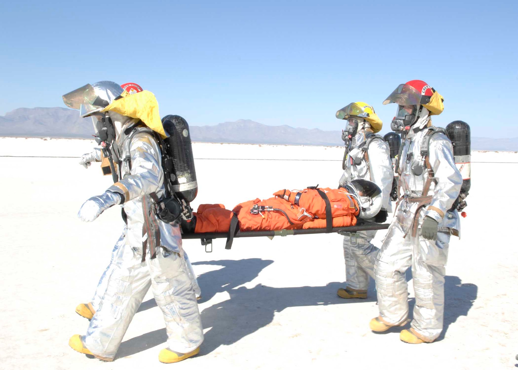 Holloman Fire Fighters care for a shuttle team member in a simulated shuttle landing exercise. Approximately 60 members from Holloman, White Sands Missile Range and the National Aeronautics and Space Administration (NASA) came together for a shuttle emergency landing exercise at the White Sands Space Harbor, Oct. 30. (U.S. Air Force photo/Airman 1st Class Rachel A. Kocin)