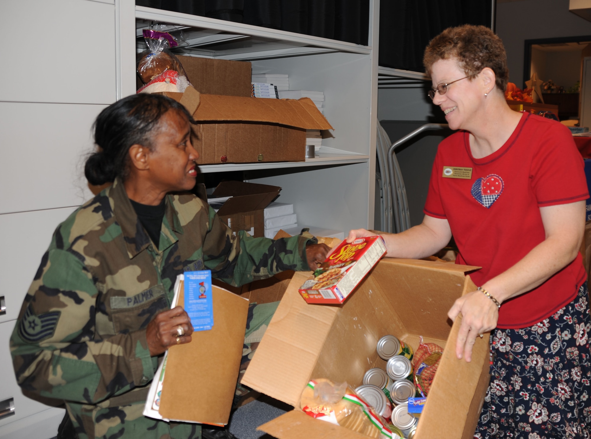 932nd Airlift Wing, Air Force Reserve member Tech. Sgt. Adriane Palmer, brings more food to Deborah Teague in the family readiness office to help with Thanksgiving. She and others are helping to create baskets of food for fellow military members. Donations of food and money have helped the wing to take care of members who might need a little assistance this year during the holidays.  You can get involved by talking to them on the next drill weekend. (U.S. Air Force/Maj. Stan Paregien) 