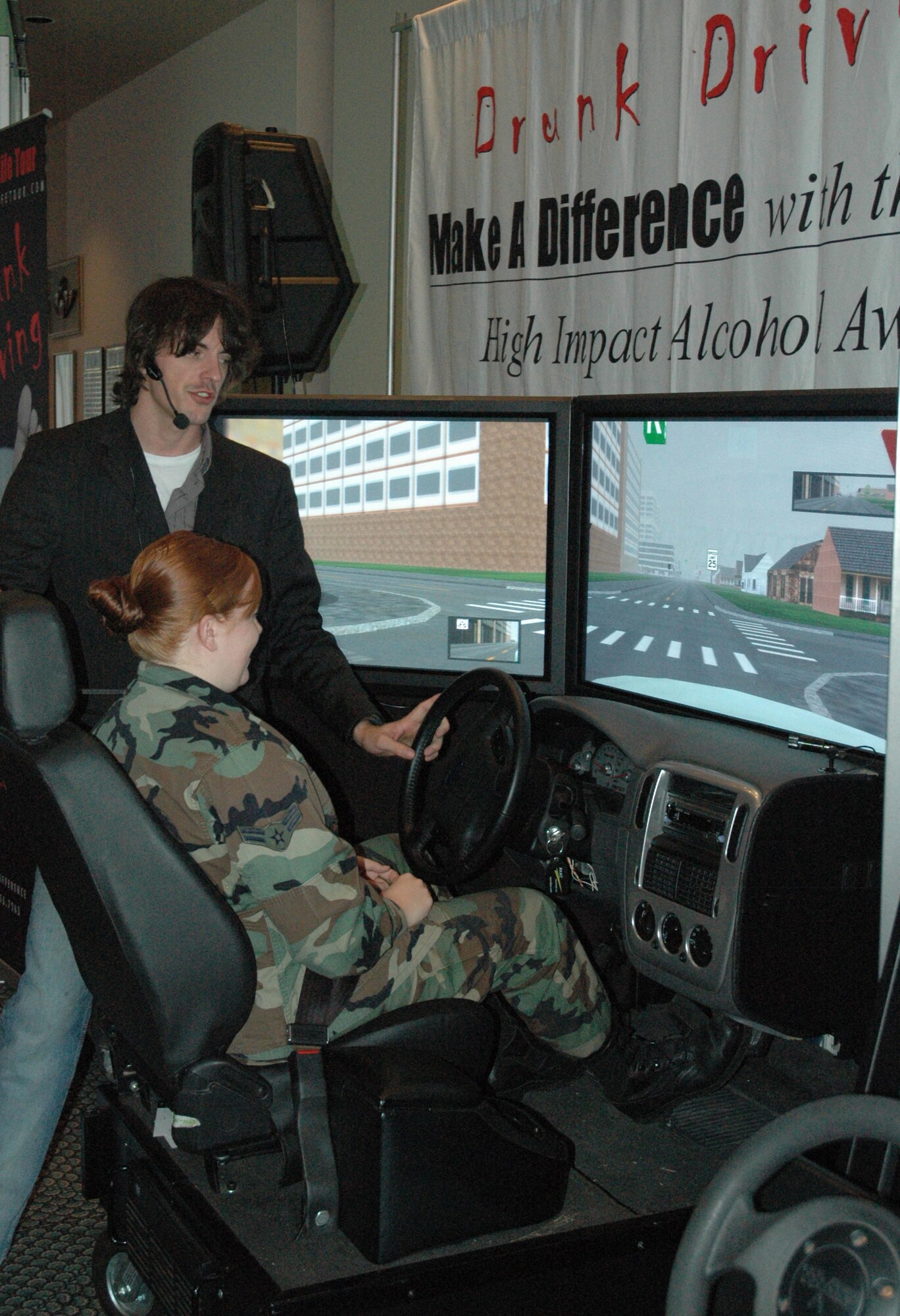 Brian Beldyga, Save-A-Life Tour speaker, demonstrates to Airman 1st Class Jessica Lamb, 325th Medical Group logistics and Airmen Against Drunk Driving director, how to use the multi-million dollar Driving Under the Influence simulator.  (U.S. Air Force photo by Airman 1st Class Anthony J. Hyatt)