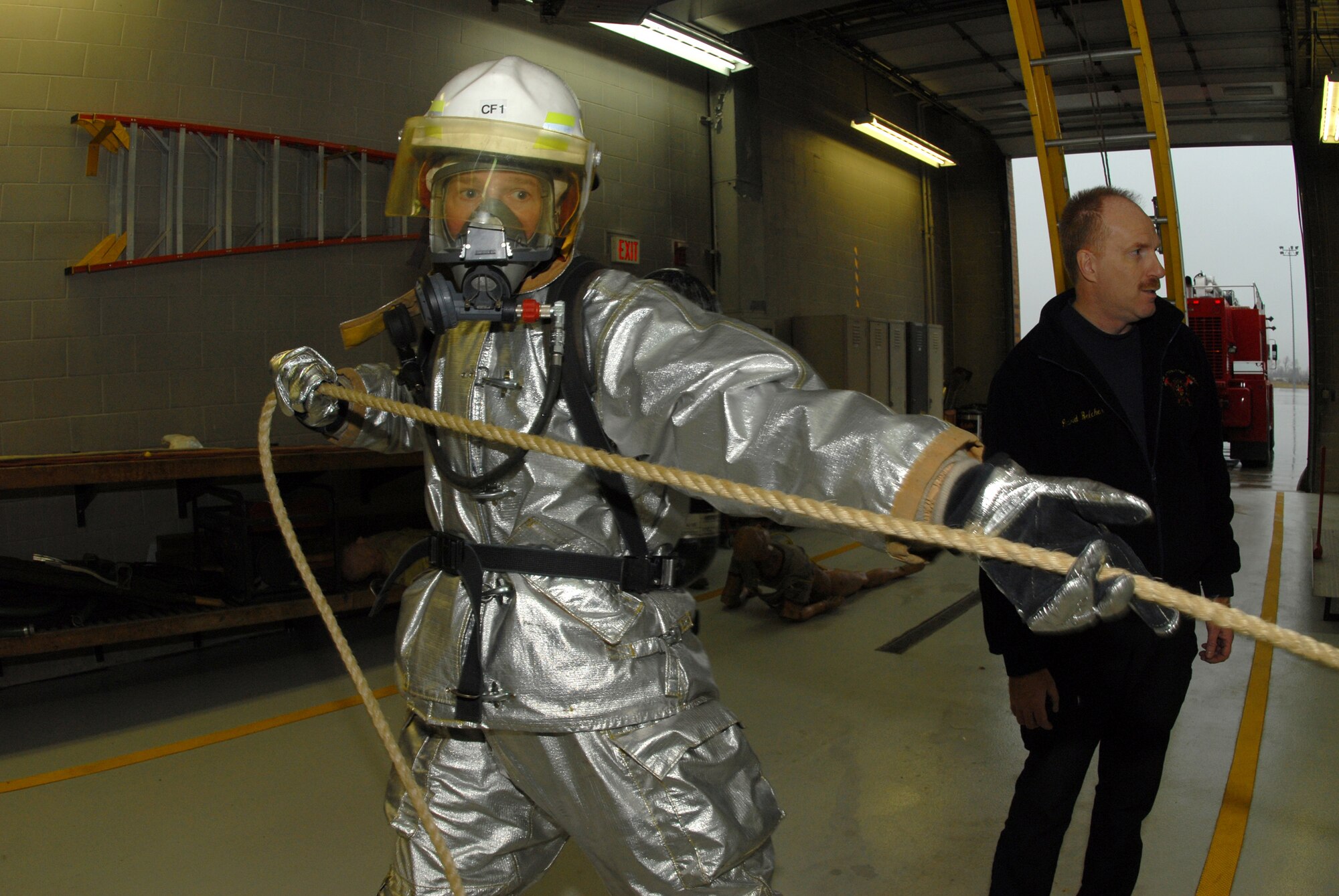 Maj, John C. Gibbs, the 119th Civil Engineer Squadron commander, pulls a rope with a weight on the end as part of a fire fighter obstacle course Nov. 6 in the North Dakota Air National Guard fire hall on the east edge of the Hector International Airport runway, Fargo, N.D.  The obstacle course is an annual fire fighter fitness testing requirement to demonstrate fire fighting readiness and capabilities.  (NDANG photo by Senior Master Sgt. David H. Lipp) (Released)  
