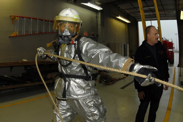 Maj, John C. Gibbs, the 119th Civil Engineer Squadron commander, pulls a rope with a weight on the end as part of a fire fighter obstacle course Nov. 6 in the North Dakota Air National Guard fire hall on the east edge of the Hector International Airport runway, Fargo, N.D.  The obstacle course is an annual fire fighter fitness testing requirement to demonstrate fire fighting readiness and capabilities.  (NDANG photo by Senior Master Sgt. David H. Lipp) (Released)  
