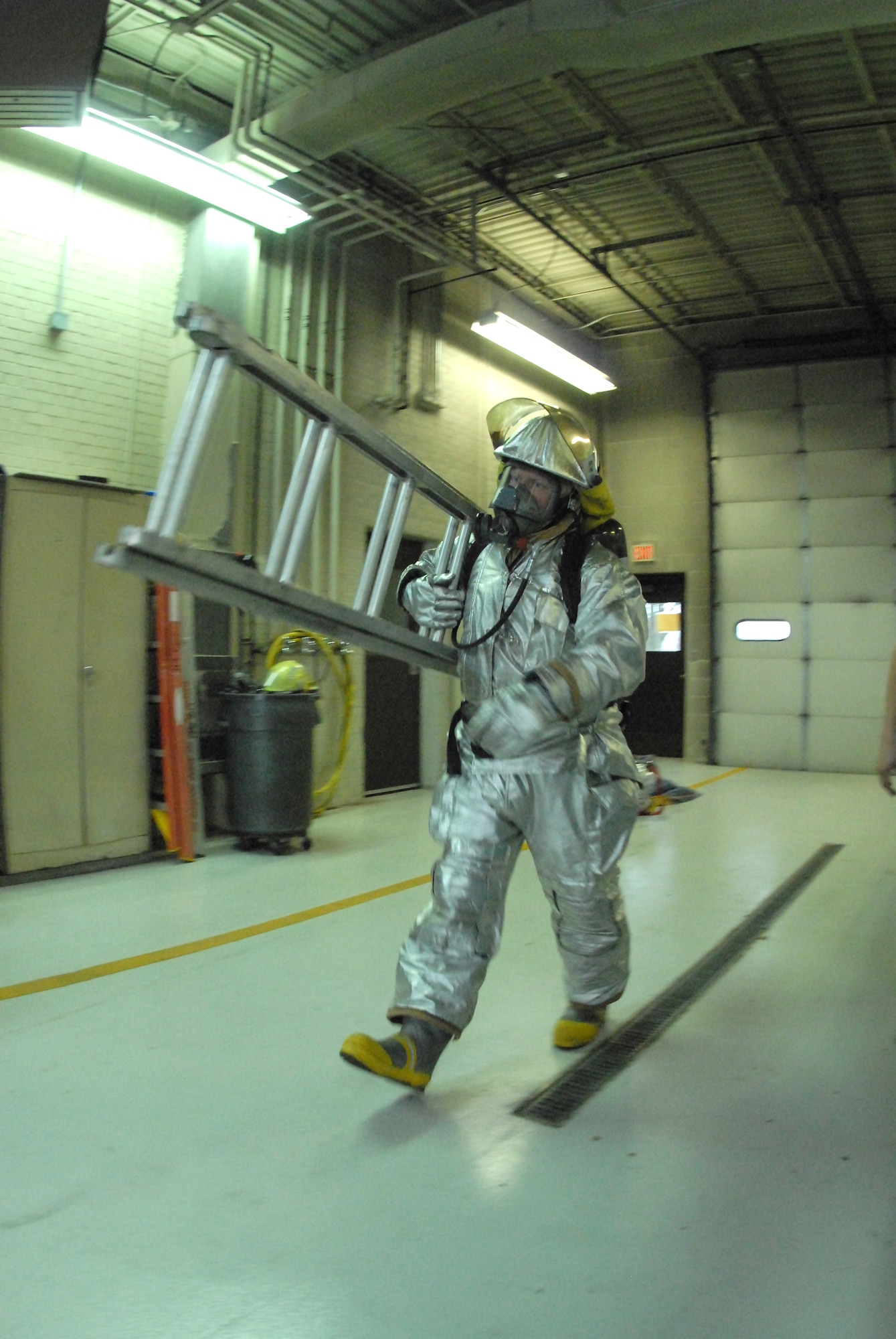 Tech Sgt. Tad R. Brown, a 119th Civil Engineer Squadron fire fighter, carries a ladder during a timed fire fighter fitness test Nov. 6 in the North Dakota Air National Guard fire hall on the east edge of the Hector International Airport runway, Fargo, N.D.  The fitness test is an annual requirement for the fire fighters and includes various obstacles designed to simulate challenges that they might encounter during fire fighting and fire victim rescue attempts.   (NDANG photo by Senior Master Sgt. David H. Lipp) (Released)
  

