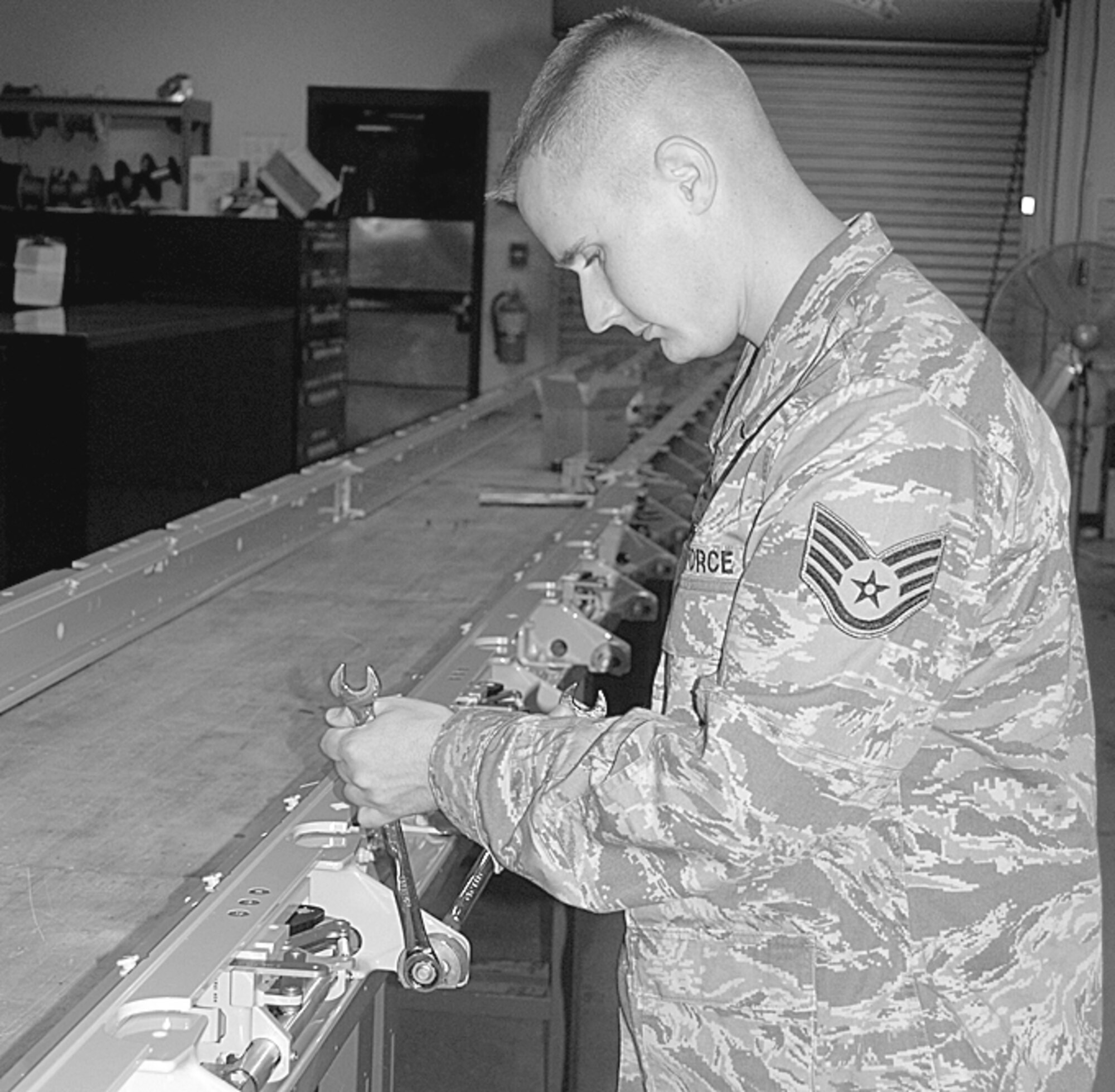 Staff Sgt. Everett Smith, 2nd Airlift Squadron, installs new floor tie-down washers, also called cookies, onto aircraft door rails. The aircraft door rails are what hold down palettes on aircraft. (U.S. Air Force Photo by Emily Farrington-Smith)