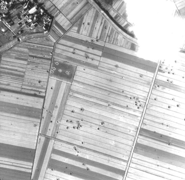 A World War II aerial photograph, taken after a bombing mission in Germany, shows craters created by bombs exploding and smaller holes resulting from bombs that did not explode on impact. Photos like this from the Air Force Historical Research Agency are key in determining whether an area in Germany is safe for commercial development. (Courtesy photo) 