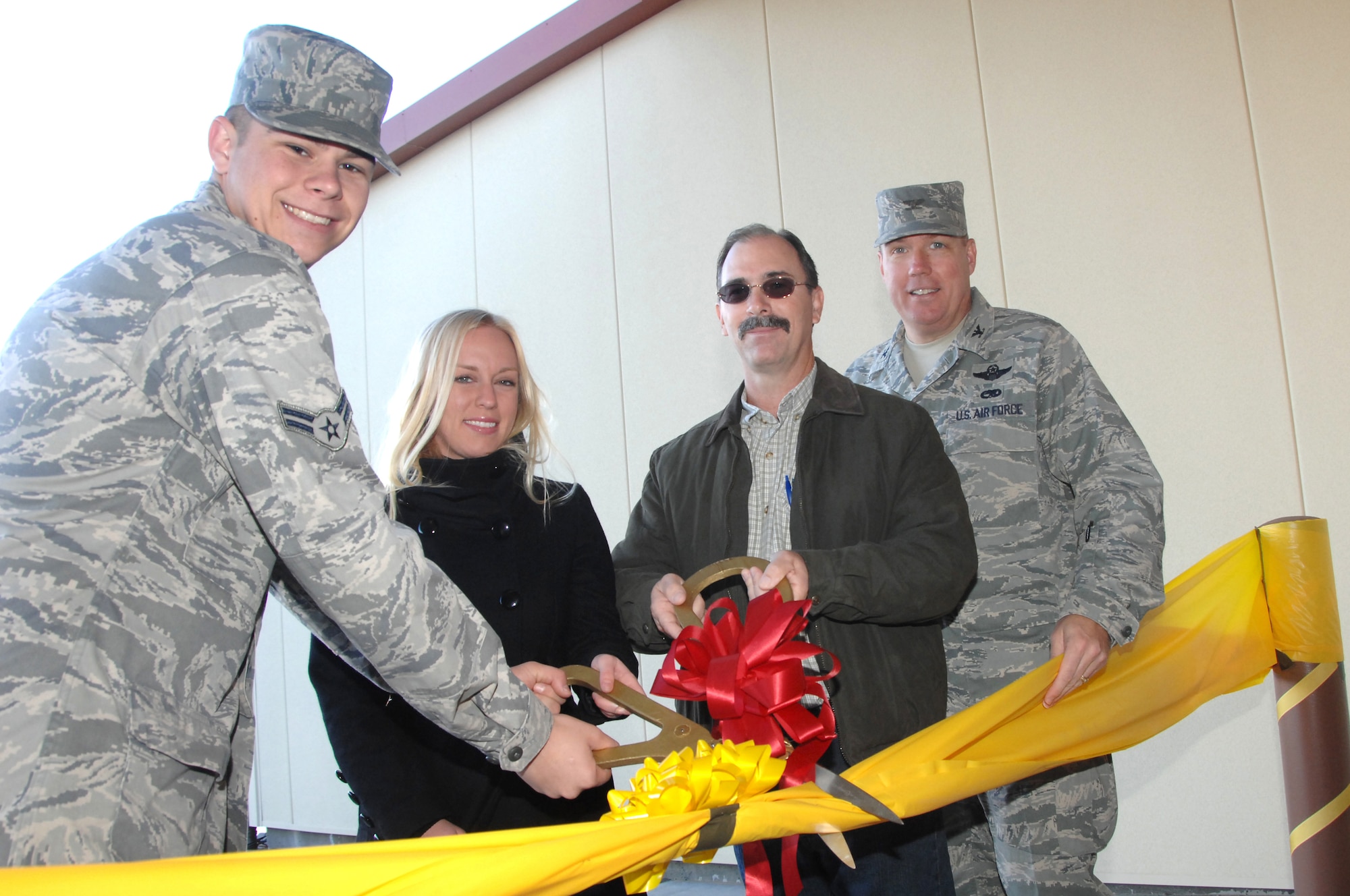 From left, Airman 1st Class Roger Hooper, Annie Winterfield, representing Congresswoman Ellen Tausher (D-Calif.), Jeff Griffin, representing building contractor R.A. Burch and Col. John Lipinski, 615th Contingency Response Wing commander, cut the ribbon on the new Global Reach Development Center here Nov. 5. (U.S. Air Force photo/Amanda Lopez)