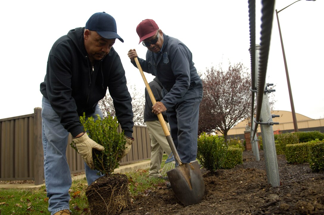 Warren Hawkins and Wade Thomas, 316th Civil Engineering Squadron grounds keepers, plant shrubs as a part of base beautification near Base Operations Nov. 6.(U.S. Air Force photo by Senior Airman Renae Kleckner)