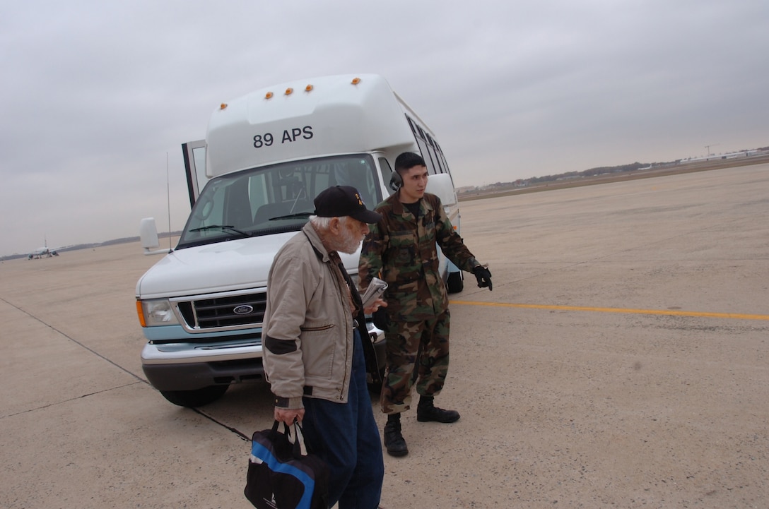 Senior Airman Roman Ramirez, 89th Aerial Port Squadron passenger service agent, directs a Space-A passenger to a waiting aircraft. (U.S. Air Force photo by Bobby Jones)