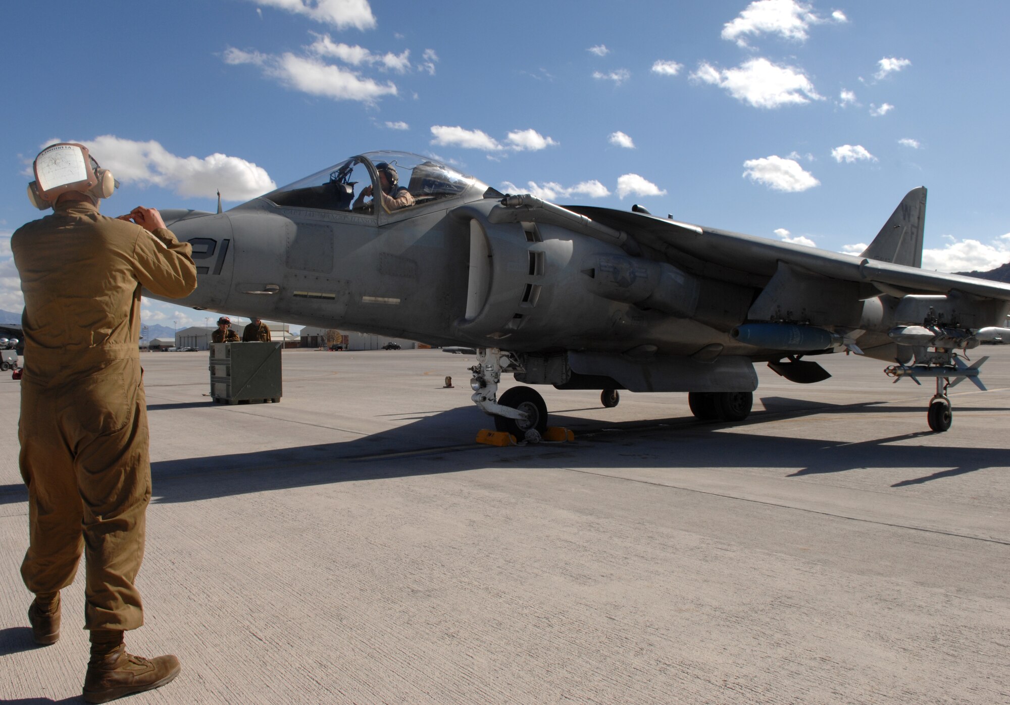 CREECH AFB, Nev. -- U.S. Marine Corps Lance Cpl. Marc Longoria (left), an AV-8B Harrier plane captain, signals Maj. Bret Ritterby, an AV-8B Harrier pilot, before take off at Creech Air Force Base, Nev., Nov. 4. The Marines are assigned to Marine Attack Squadron 513, Marine Corps Air Station Yuma, Ariz. The Squadron was here to execute joint and high altitude forward base operations alongside the MQ-1 Predators in preparation for deployment to Southwest Asia. (U.S. Air Force Photo/Senior Airman Larry E. Reid Jr.) 
