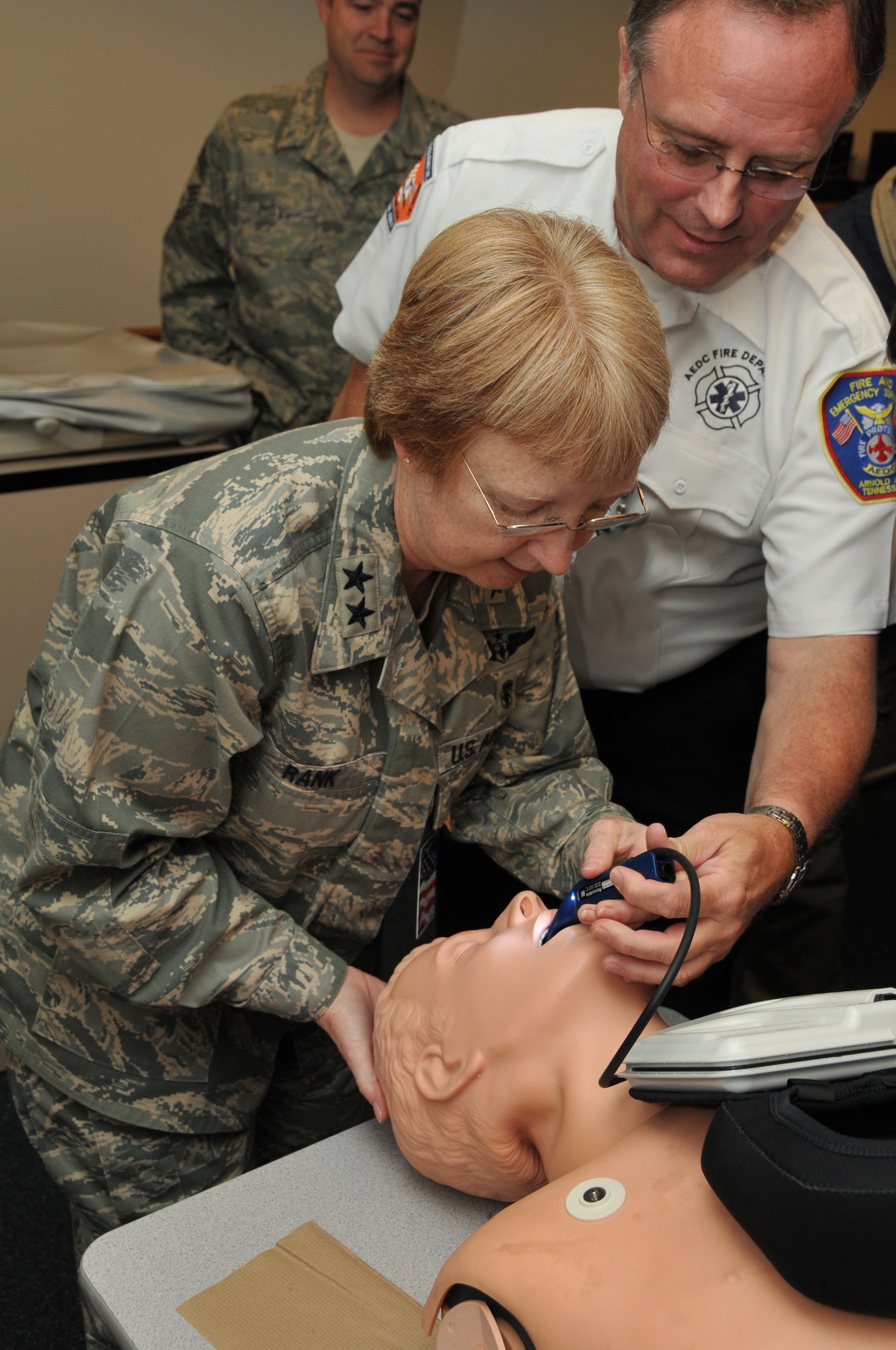 Caption for 081027-F-6163H-085: Wade Campbell, EMS safety officer, helps Maj. Gen. Melissa Rank use a GlideScope Ranger Video Laryngoscope, which allows EMS personnel to establish an advanced airway, on a dummy during her visit of the Fire Department/EMS facilities. (Photo by David Housch)