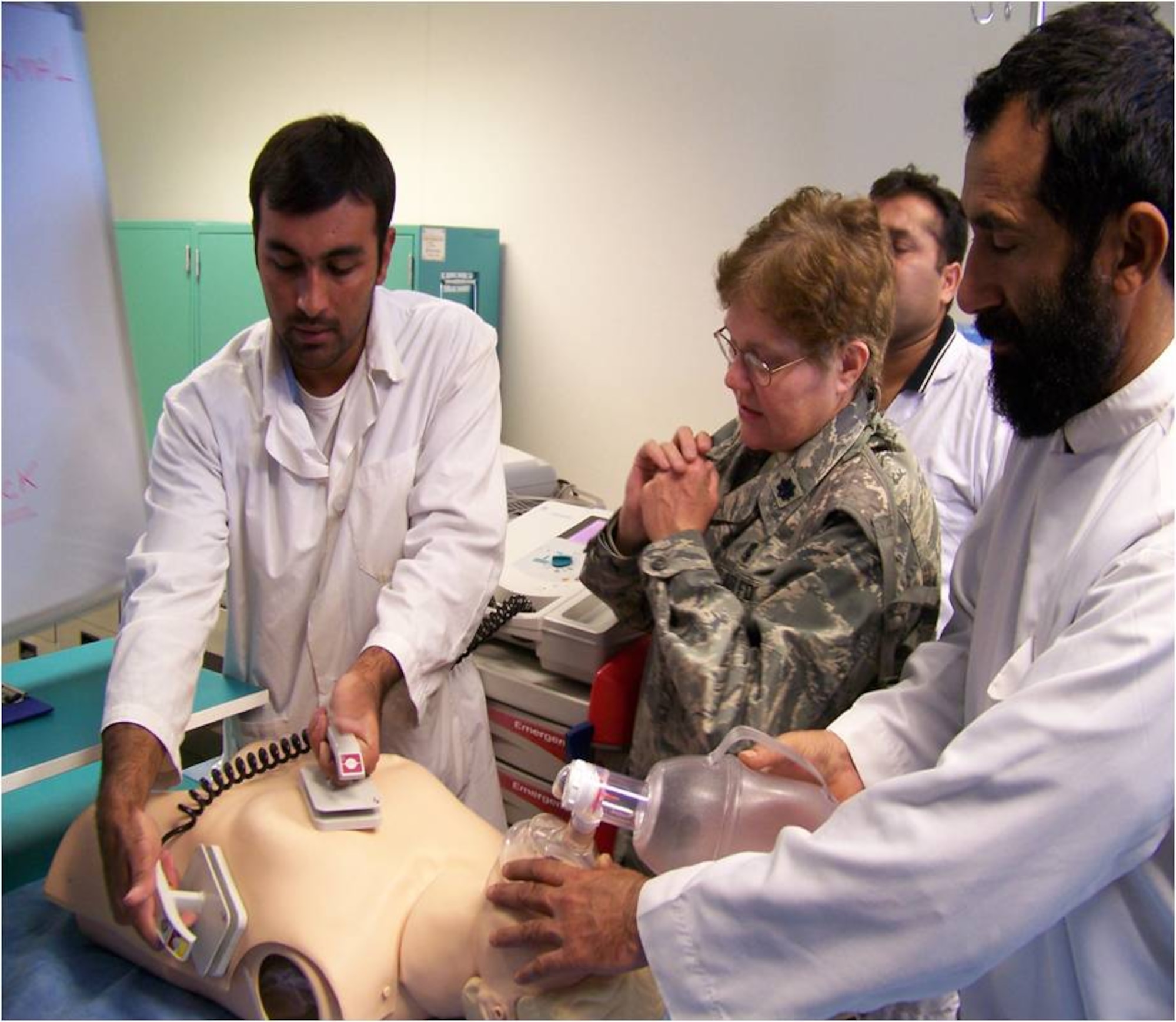 Lt. Col. Susan Bassett, the chief nurse at the 882nd Training Group, helps Afghan nurses demonstrate how to defibrillate a patient who is in cardiac arrest during a 365-day deployment to the 205th Afghan Regional Security Integration Command in Kandahar, Afghanistan. (U.S. Air Force photo) 