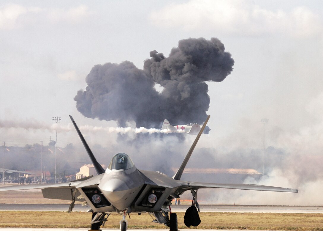 The Pearl Harbor reenactment of "Tora! Tora! Tora!" fills the sky with smoke as a Japanese Zero streaks by behind an F-22 Raptor during AirFest 2008 at Lackland Air Force Base, Texas. (U.S. Air Force photo/Robbin Cresswell)