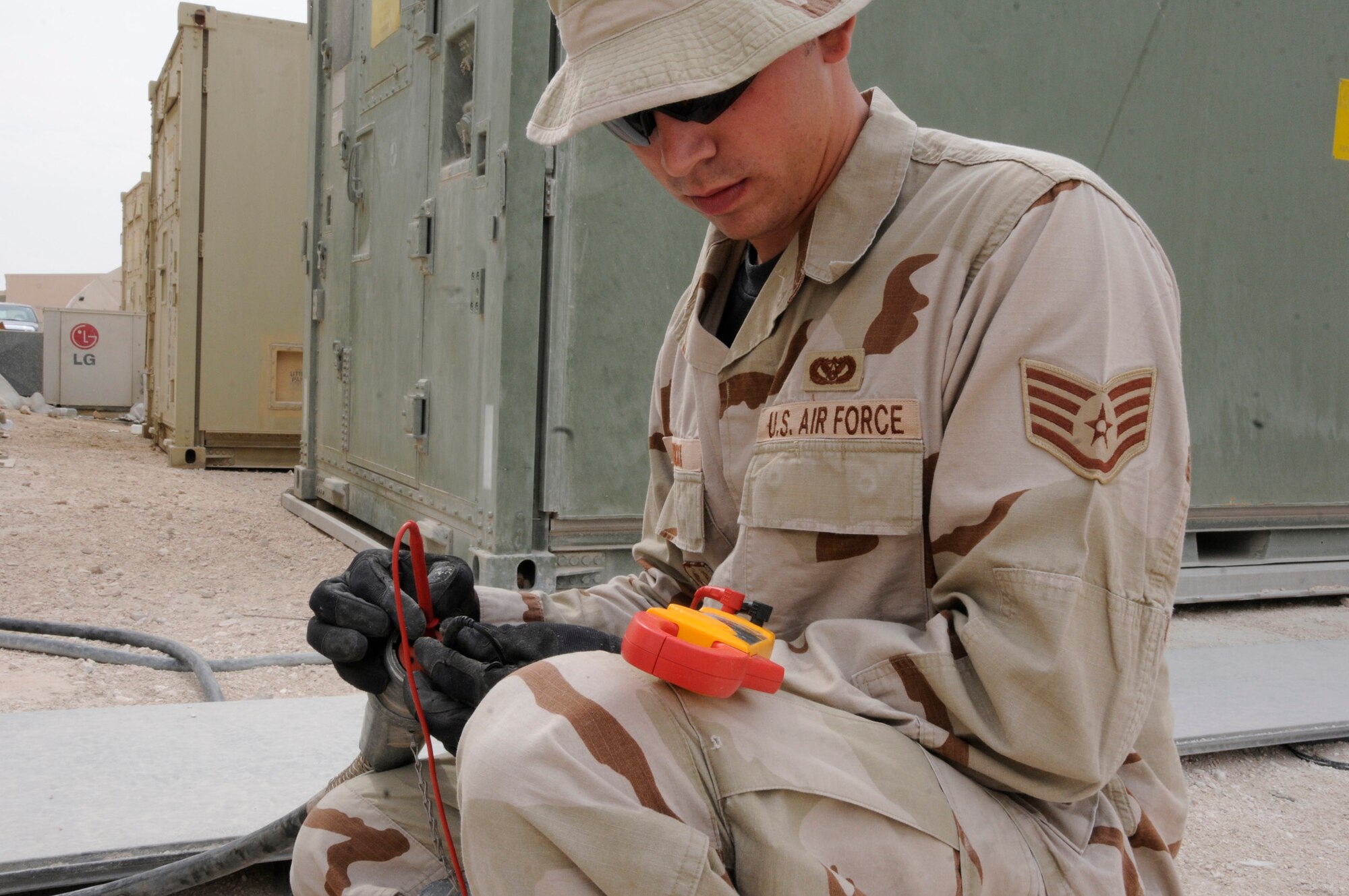 Staff Sgt. Matthew Sawicki, electrical systems journeyman assigned to the 379th Civil Engineer Squadron, checks for proper voltage on a recently installed 60 amp cable Nov. 3, at an undisclosed location in Southwest Asia.  The electric shop wired up a three-phase 60 amp breaker and ran a cable through the back of the building to supply power to a reefer unit.  Sergeant Sawicki is a native of Modesto Calif., and deployed from Travis Air Force Base, Calif.  (U.S. Air Force photo by Tech. Sgt. Michael Boquette)
