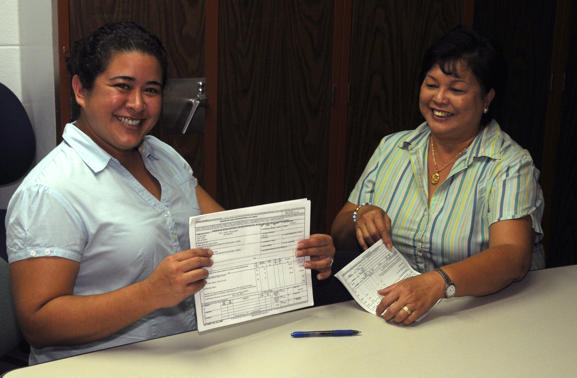 ANDERSEN AIR FORCE BASE, Guam - Jane Sasai, 36th Communication Squadron equipment control officer, signs over more than 20 desktop systems to Christine Rosario, the Special Education Assistive Technology program coordinator, on Nov. 4 on Guam.  The computers were delivered to local schools Nov. 7.  Local schools may receive donations by submitting a letter stating their needs to the Department of Defense Computer For Learning program.  (U.S. Air Force photo by Staff Sgt. Jamie Lessard)