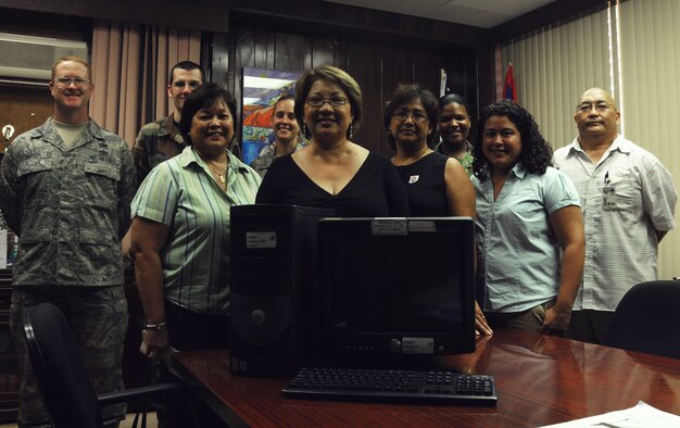 ANDERSEN AIR FORCE BASE, Guam – Posing for a group photo, in the front row, Jane Sasai, 36th Communications Squadron equipment control officer; Narrisa Bretania-Shafer, superintendent; May Camacho, special education administrator; and Christine Rosario, special education assistive technology program coordinator and, in the back row, Master Sgt. Larry Simpson, Airman 1st Class James Morris, Senior Airman Ashley Fears, Tech. Sgt. LaShanda Santiago and Mario Jallorina, all from the 36 Communication Squadron, stand around one of the Dell Optiplex computers donated to local special needs classrooms on Guam, Nov. 4.  (U.S. Air Force Photo by Staff Sgt. Jamie Lessard)