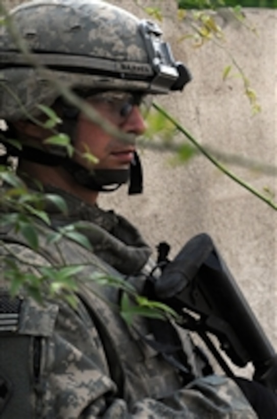 U.S. Army Pfc. Guy Barnes, from 1st Battalion, 66th Armored Regiment, 4 Brigade Combat Team, 10th Mountain Division, keeps a watchful eye while participating in Operation Iron H1018, in Muhallah 741, Al Amin, eastern Baghdad, Iraq, on Oct. 28, 2008.  Iraqi National Police and U.S. Army soldiers are working together with local residents to locate and capture suspected insurgents.  