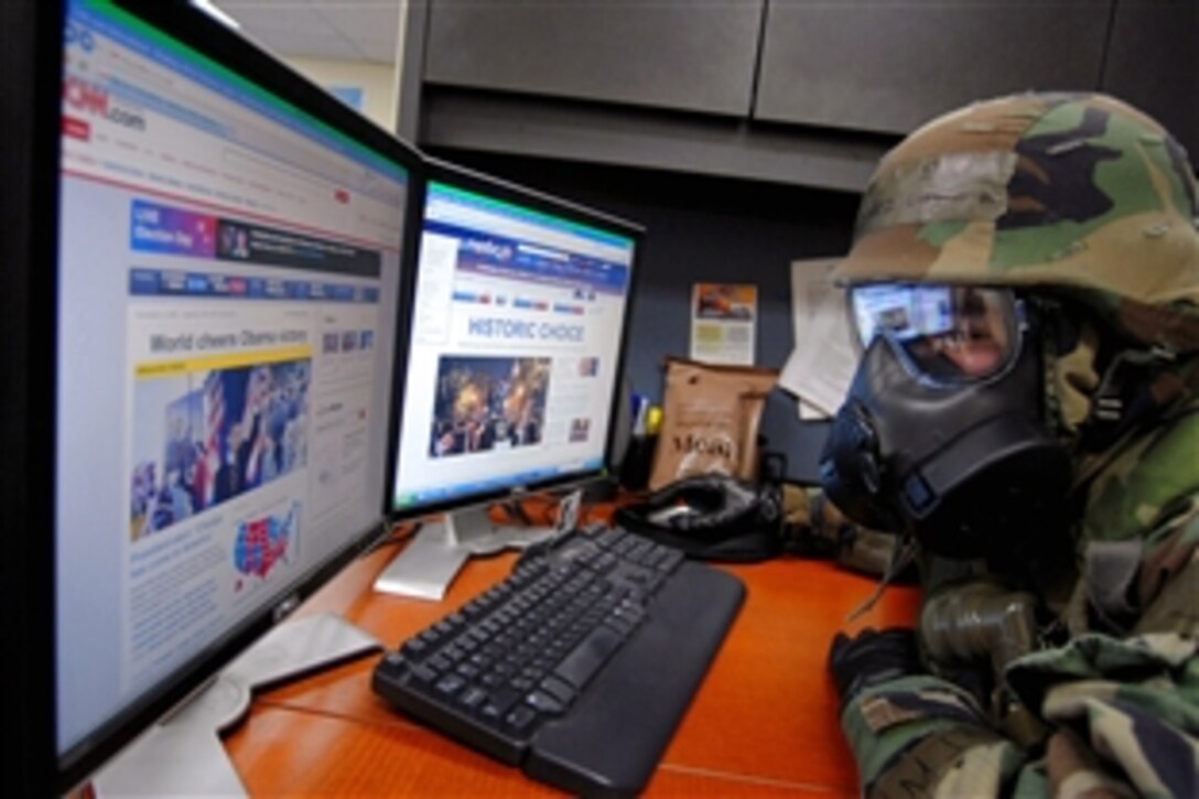 U.S. Air Force Senior Airman Gustavo Gonzalez checks the results of the U.S. presidential election, Nov. 5, 2008, while wearing protective gear during an operational readiness exercise at Kunsan Air Base, South Korea.