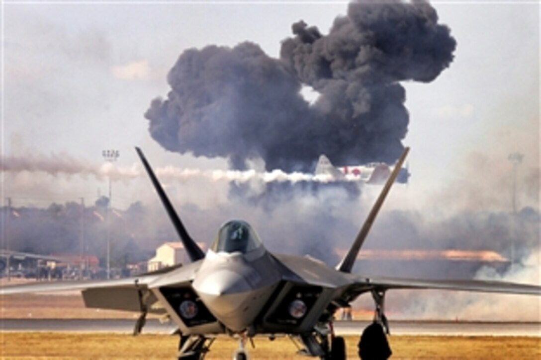 The Pearl Harbor re-enactment of "Tora! Tora! Tora!" fills the sky with smoke as a Japanese Zero streaks by behind an F-22 Raptor during AirFest 2008 at Lackland Air Force Base, Texas, Nov. 1, 2008.